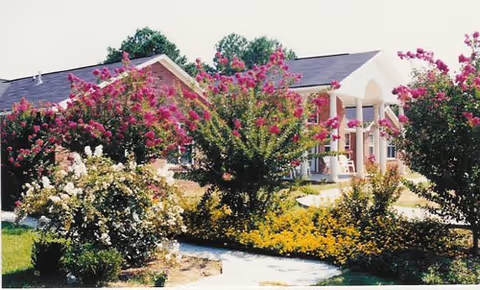 Exterior view of Mission at Alpine Rehabilitation Center with a landscaped entrance and flowering shrubs.