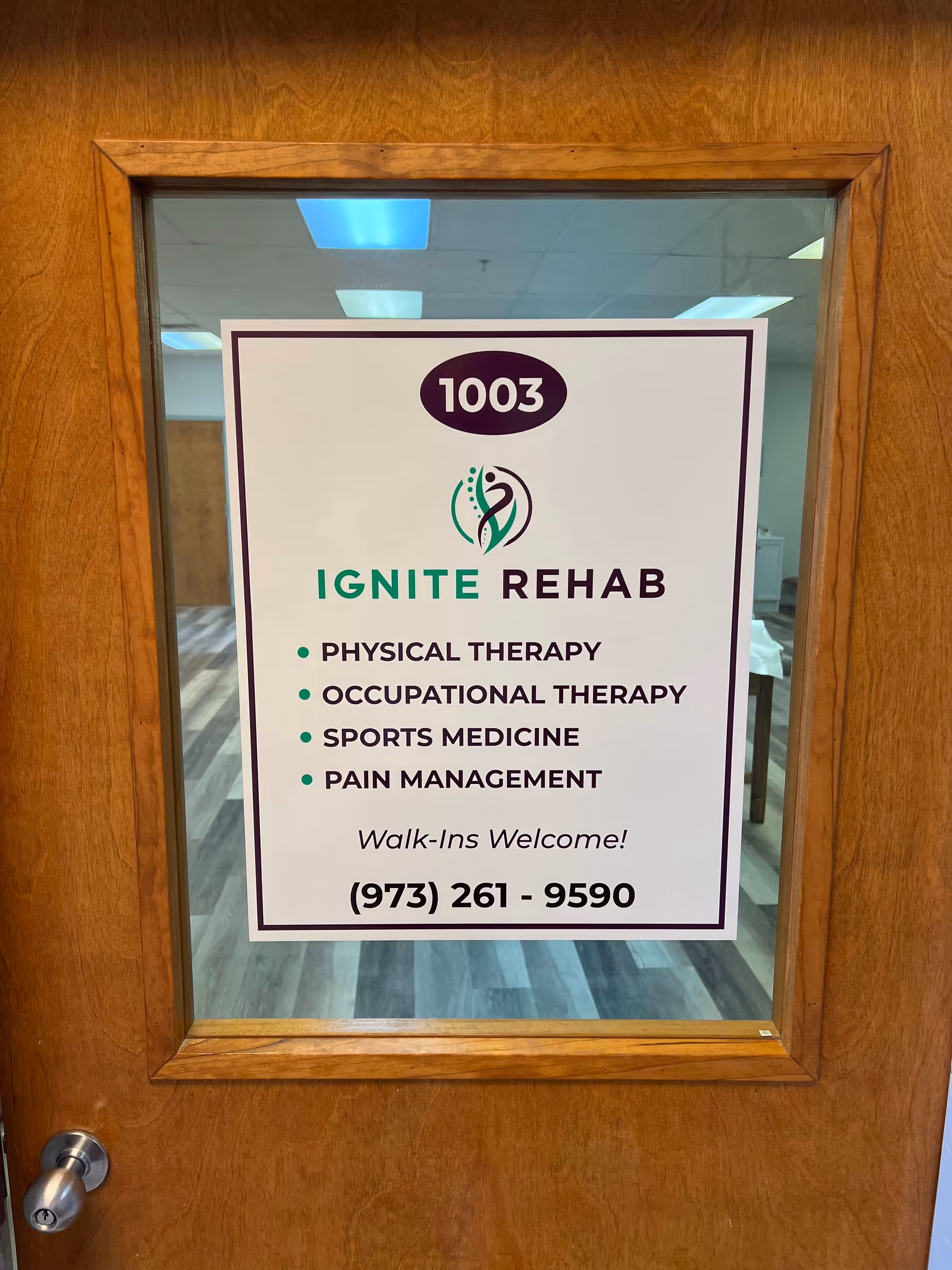 Wooden door frame with a glass panel displaying Ignite Rehab sign and therapy services.