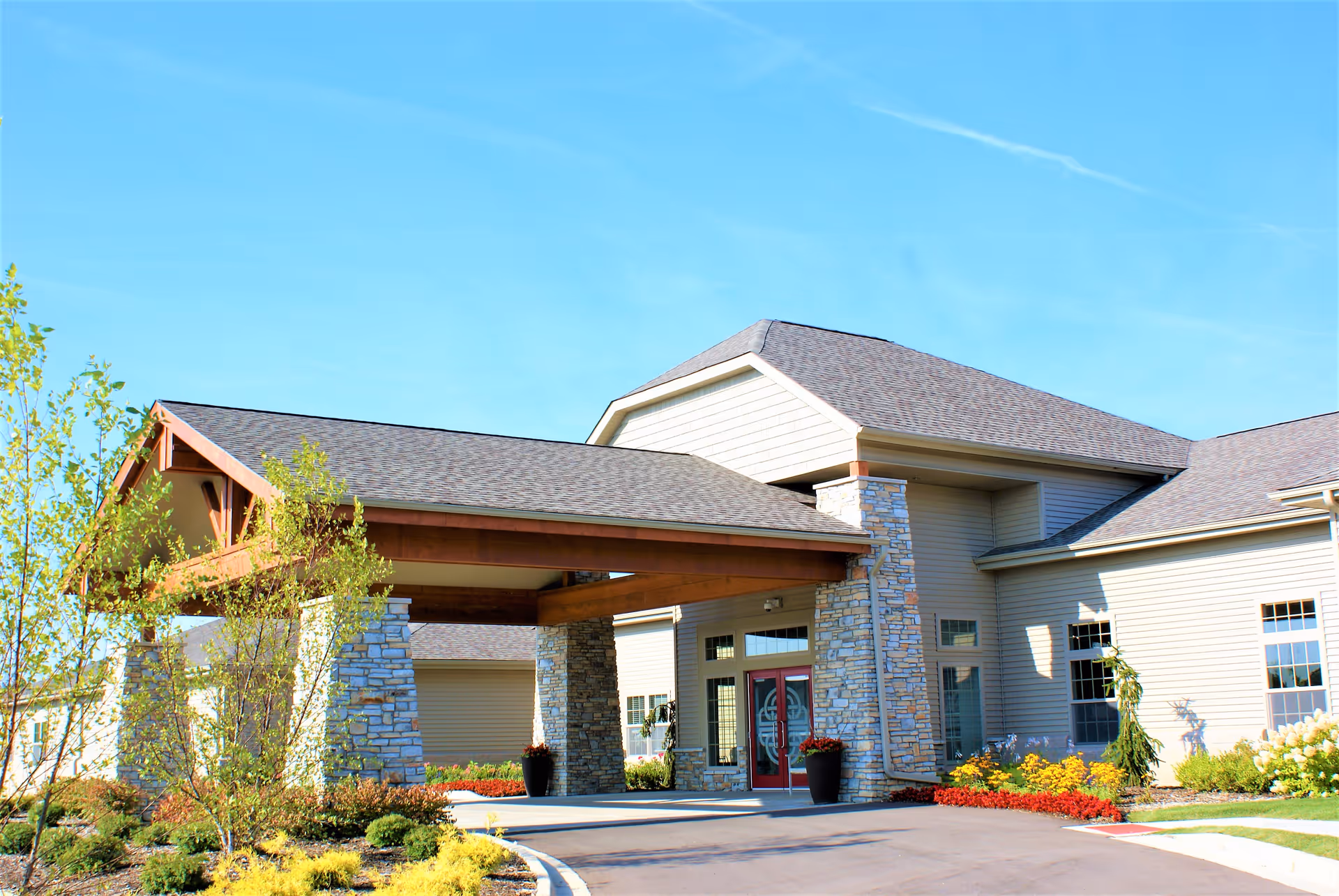 Kinwell at South Lyon exterior with entrance, stone accents, and landscaped driveway.