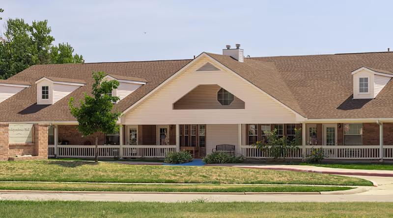 Front exterior of Independence Hall senior living facility with a long covered porch.