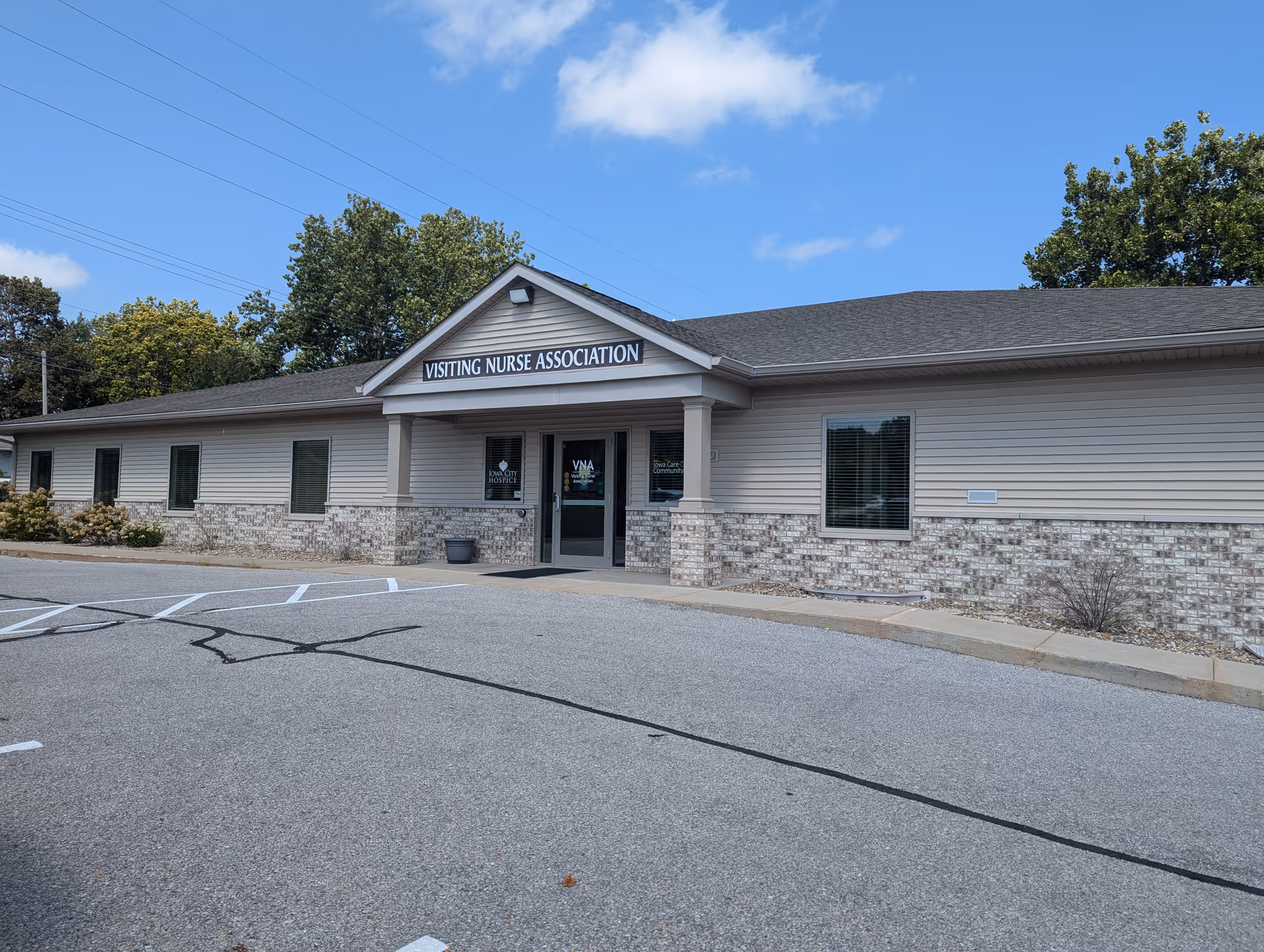 Exterior view of a single-story Visiting Nurse Association building with a parking lot.