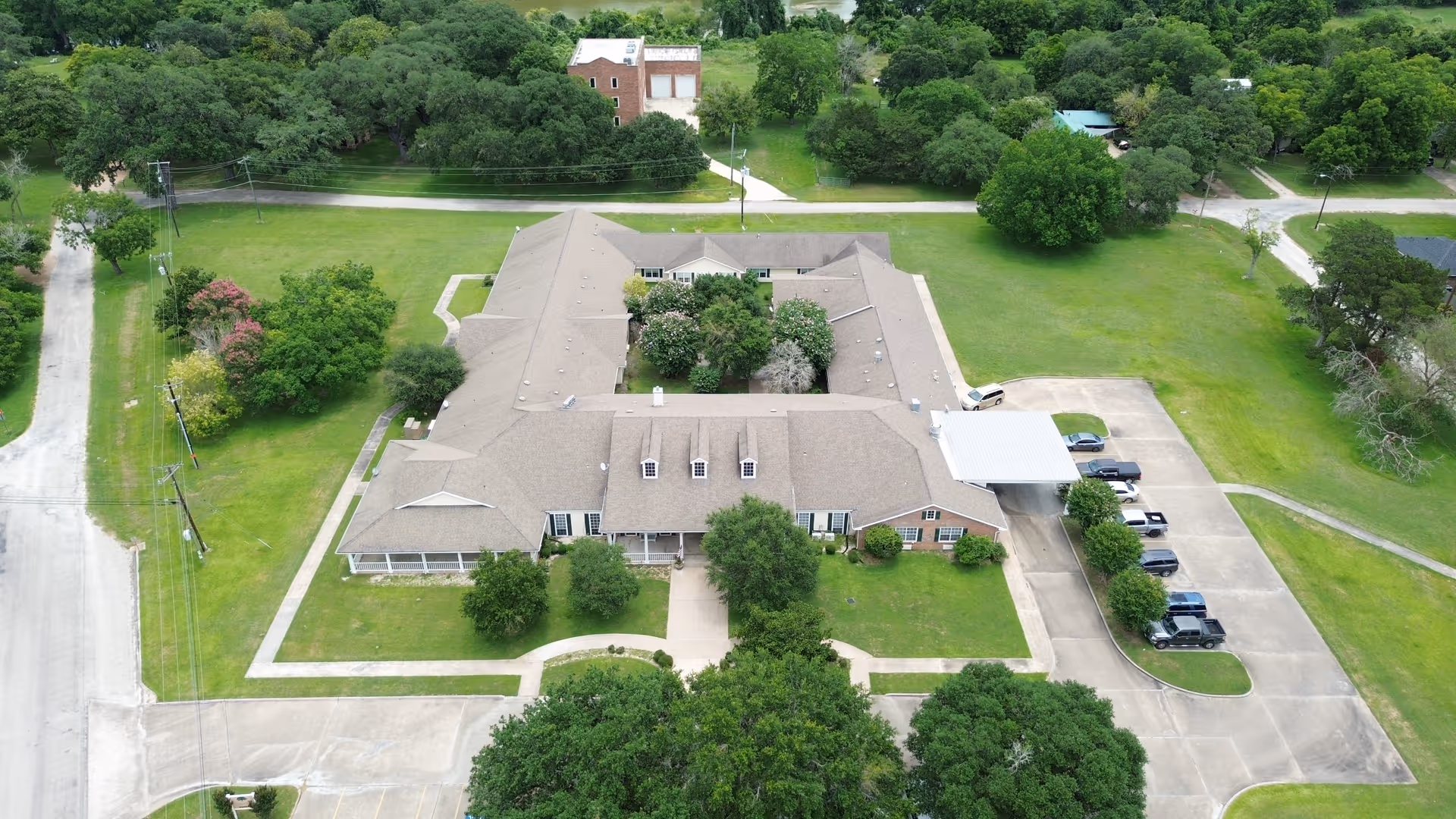 Aerial view of Columbus Oaks Assisted Living from above, showing the L-shaped building and surrounding greenery.