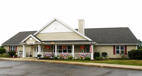 Single-story Sterling House of Monroe with a covered front porch and patriotic bunting.