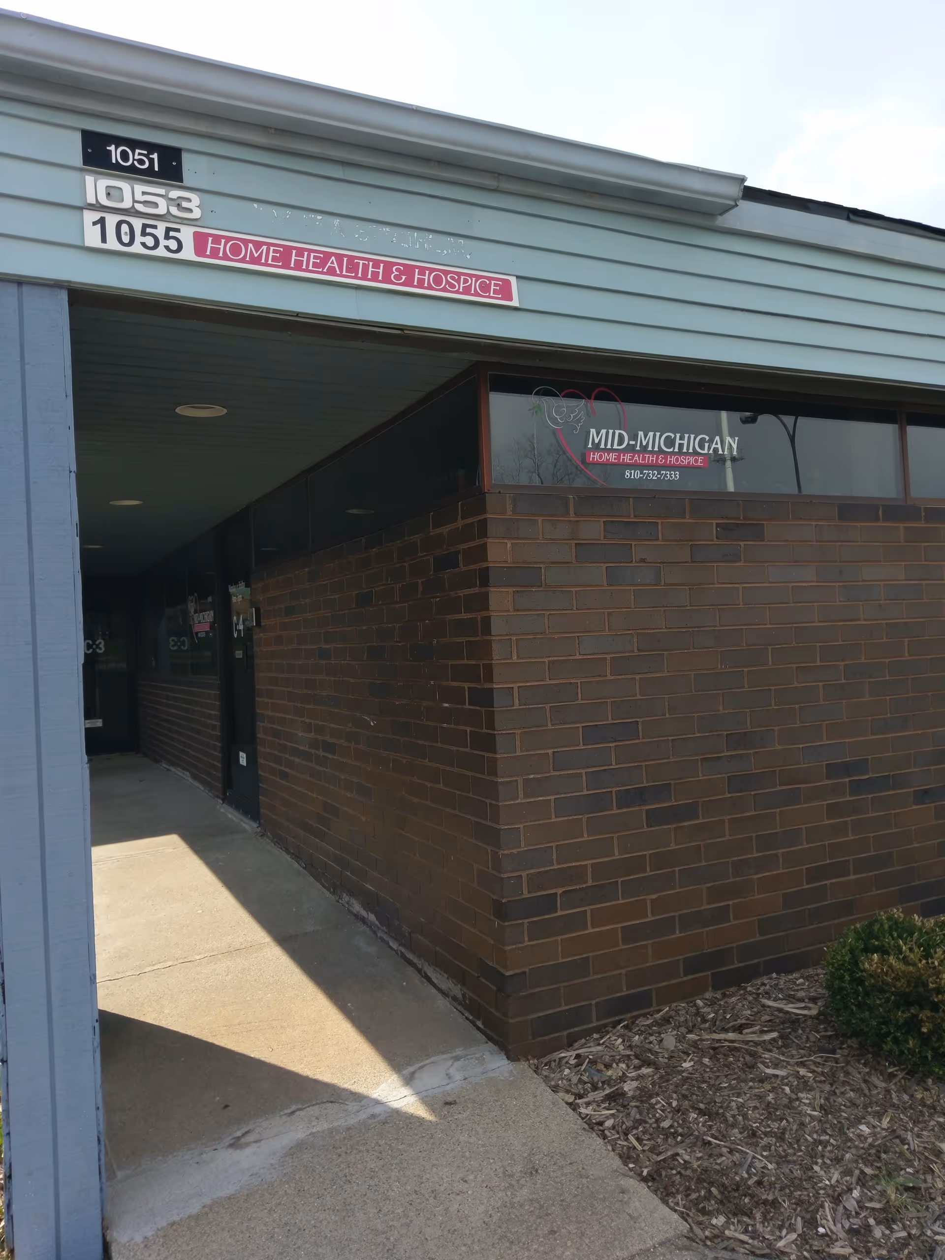 Brick building entrance with a sign reading Mid-Michigan Home Health & Hospice.