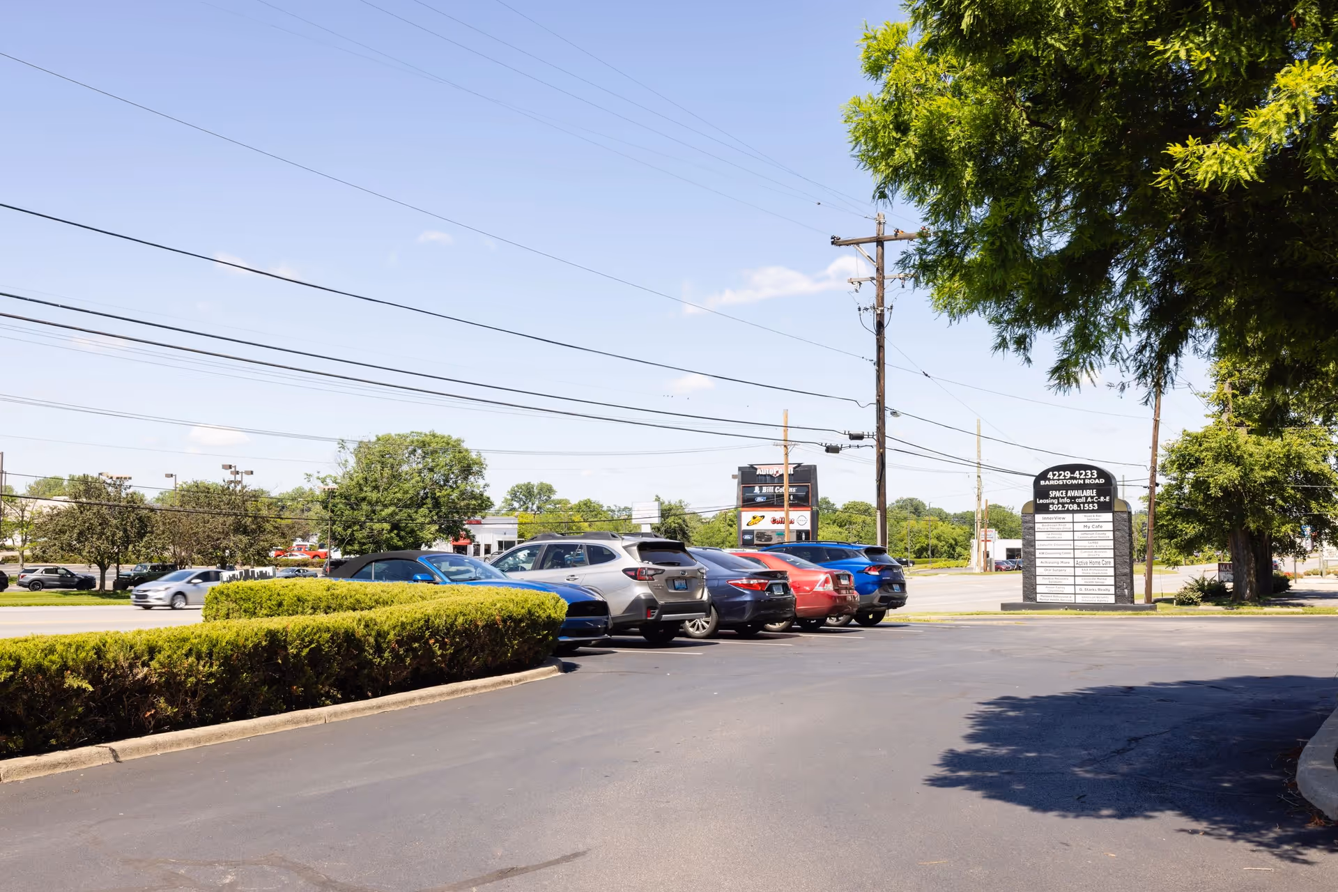 Sunny parking lot in front of a senior care facility with a tall sign.