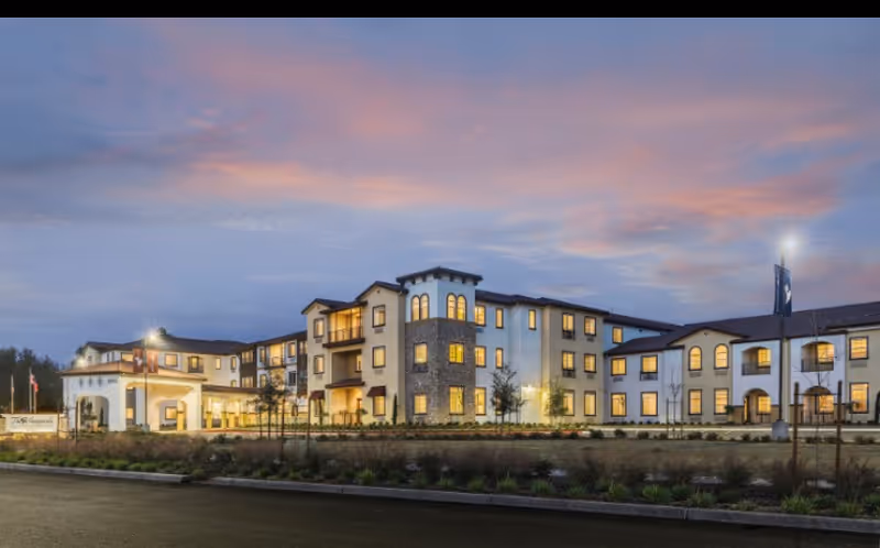 Exterior view of The Vineyards California Armenian Home building at dusk with lit windows