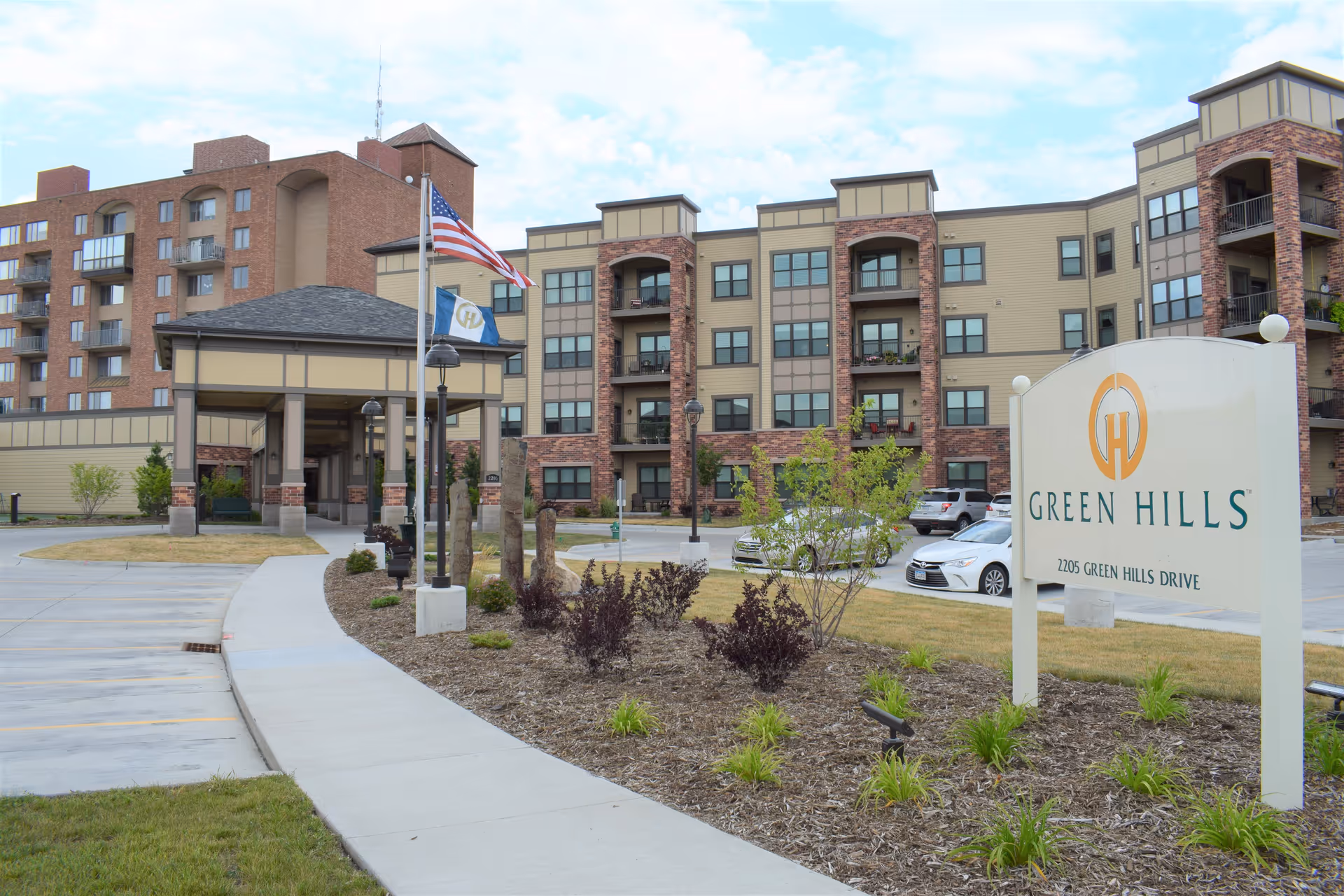 Exterior view of Green Hills Community building with sign, entrance, and parking.