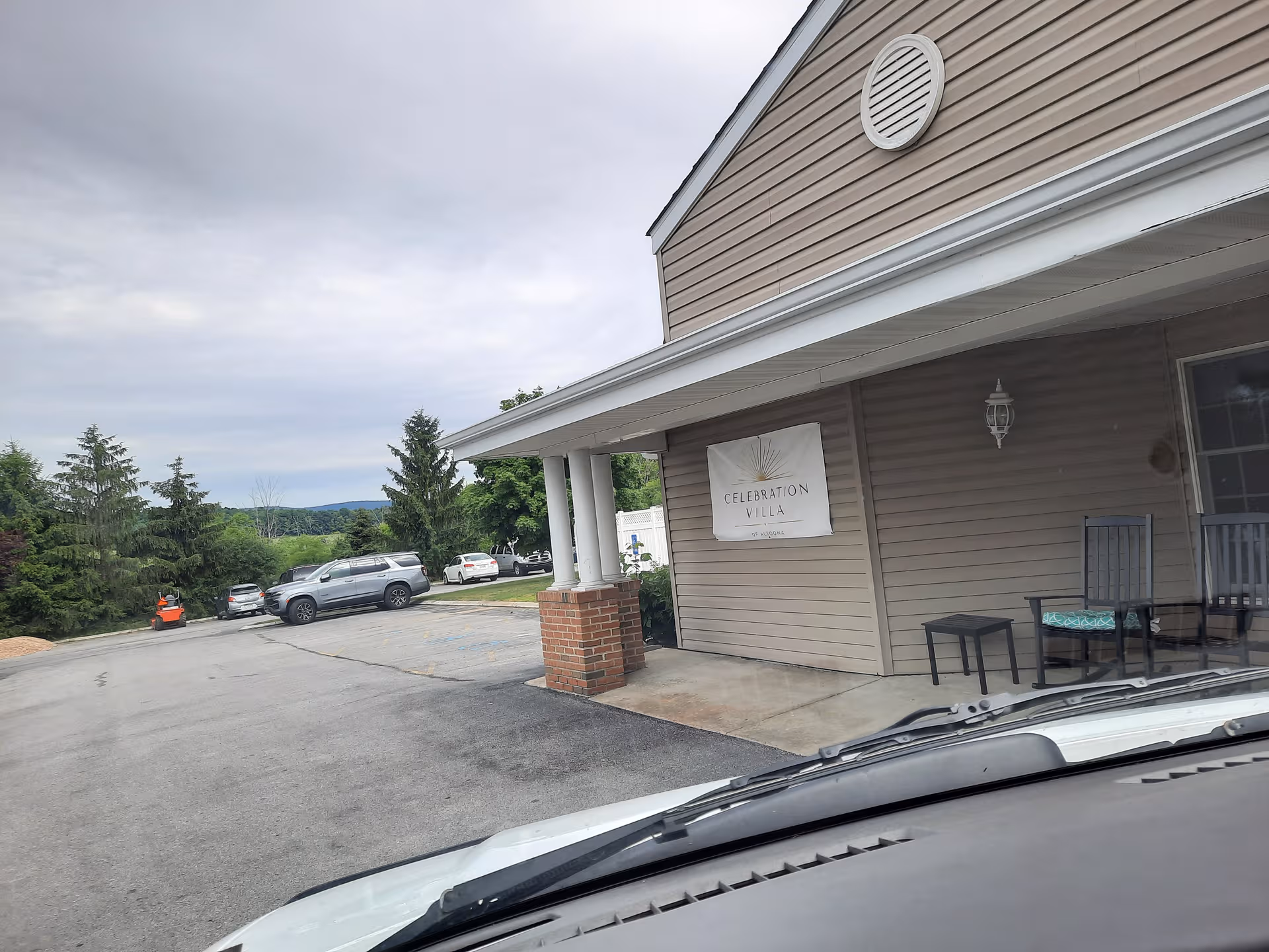 Exterior view of Celebration Villa of Altoona with parked cars and entrance sign.