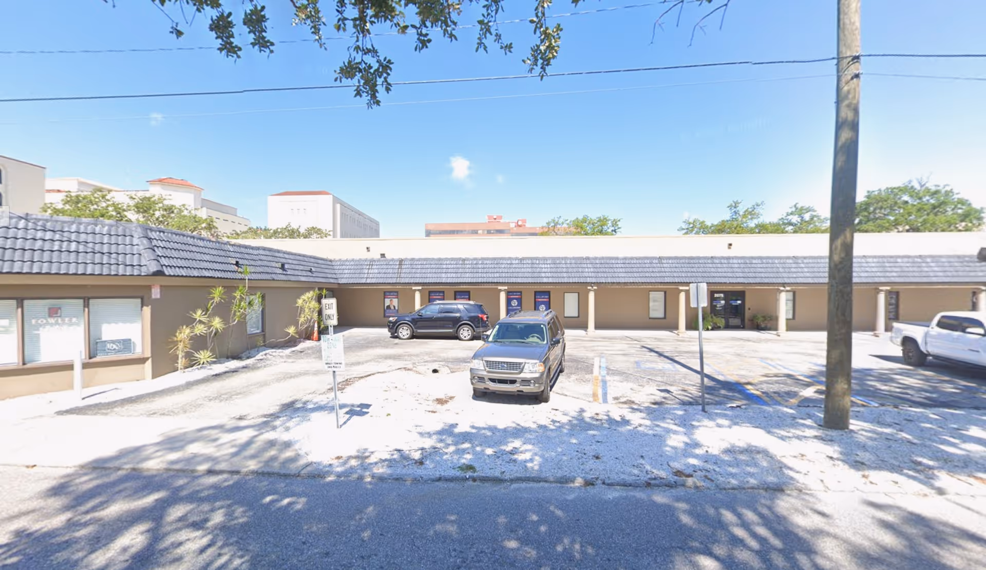 Exterior view of a single-story care facility with a long front and parked cars.
