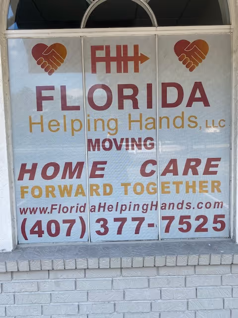 Storefront window display showing Florida Helping Hands, LLC sign with 'Moving Home Care' messaging.