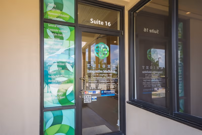 Entrance to Knight Wellness with Suite 16 glass door and green promotional panels.