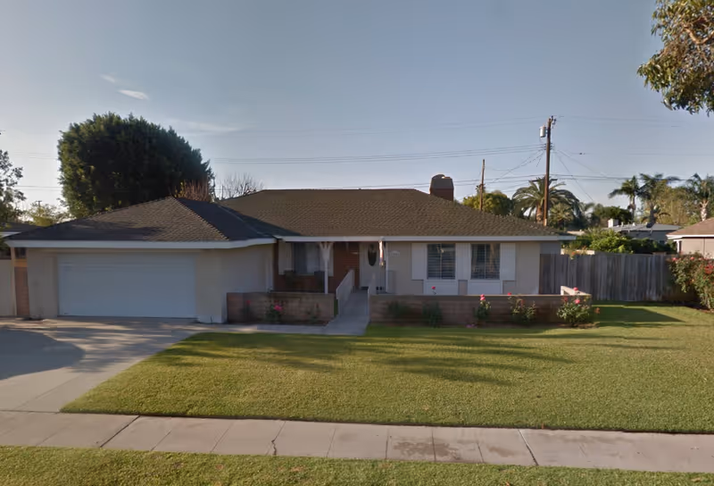 A single-story suburban house with a two-car garage, front lawn, and walkway.