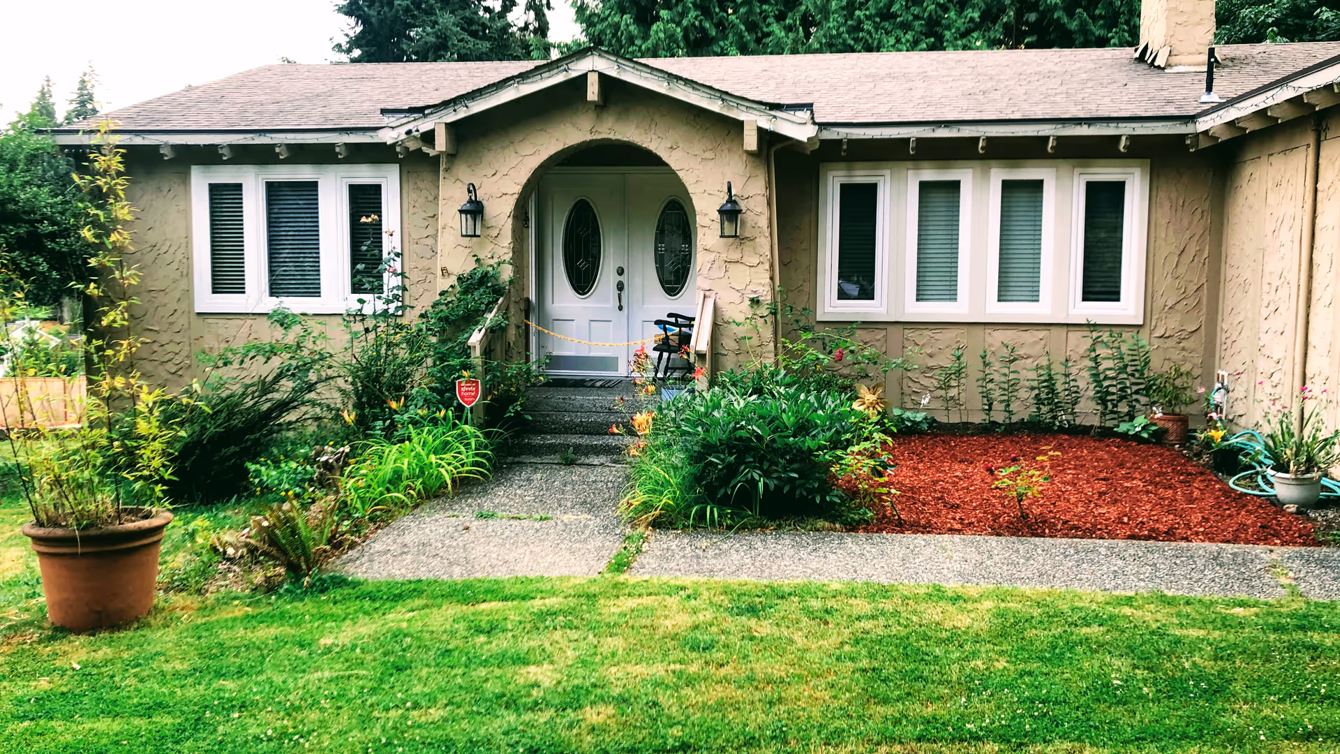 Front view of a single-story home with a manicured garden and walkway
