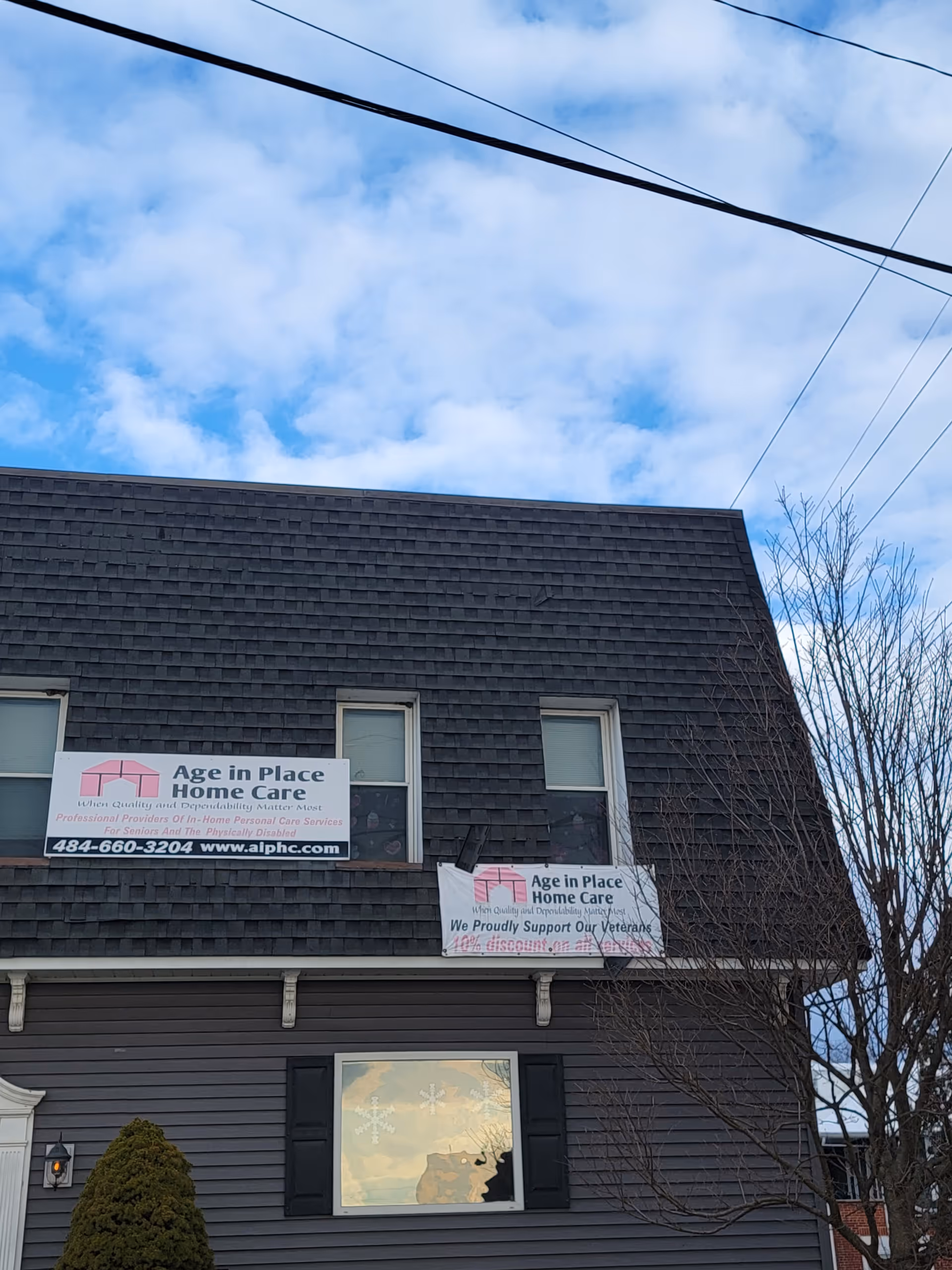 Two-story building with banners advertising Age in Place Home Care Hamburg on the front.