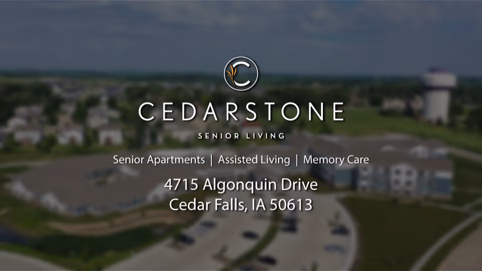 Aerial view of a senior living campus with the CedarStone Senior Living logo and address overlaid.