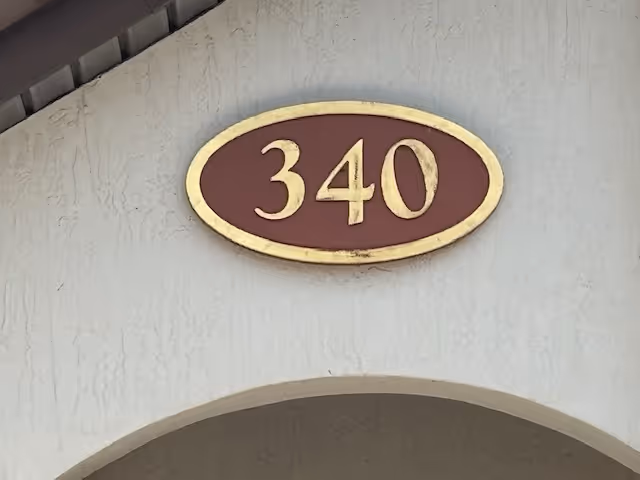 Exterior building front with a brown oval 340 plaque above an arched entrance.