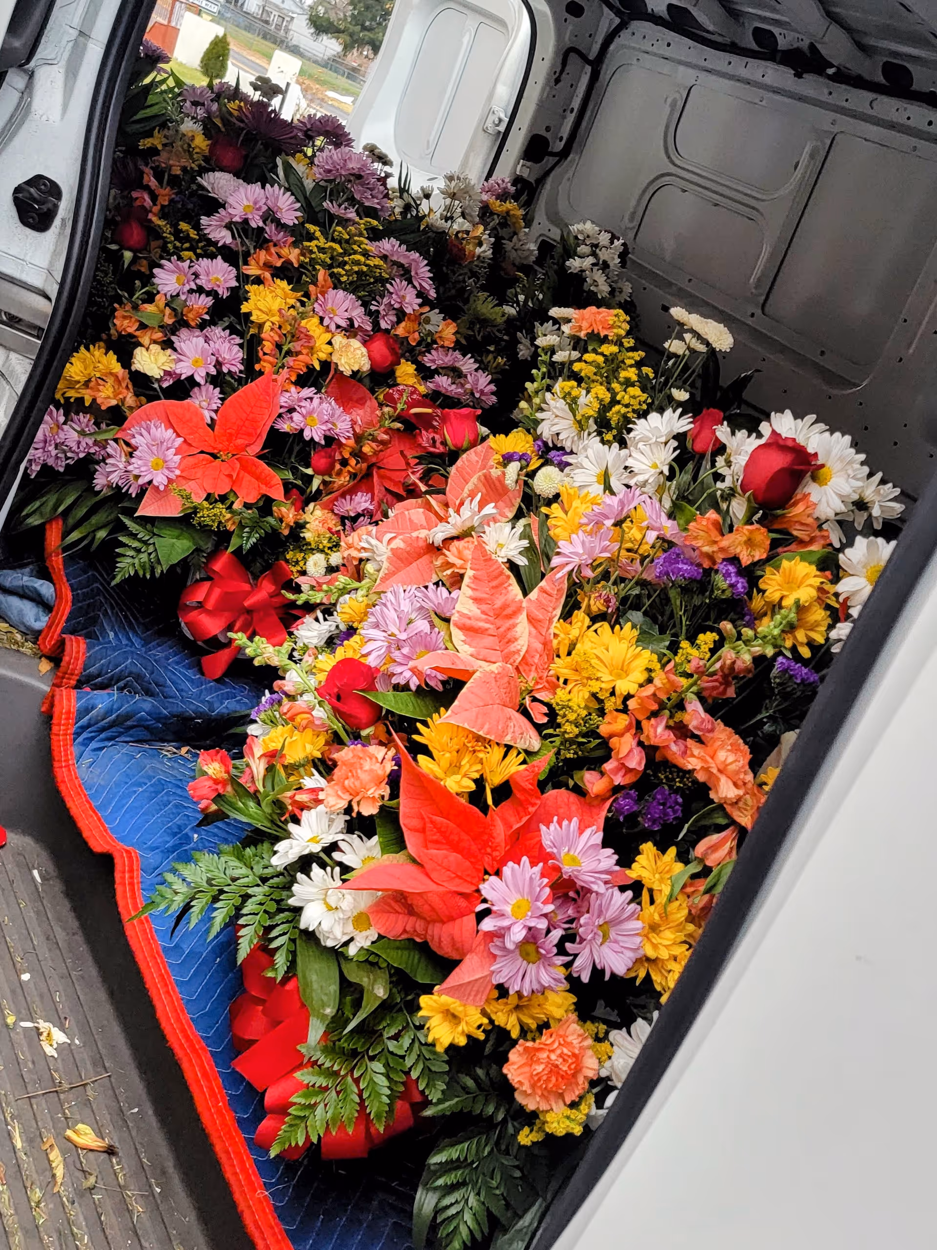 Interior of a van packed with colorful bouquets and ribbons.