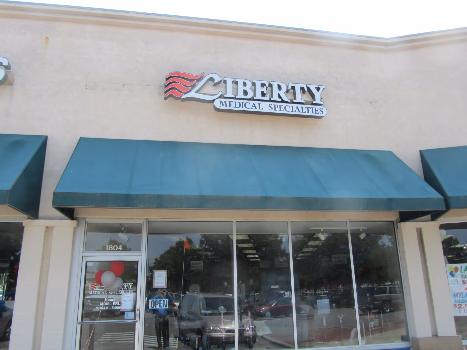 Exterior storefront of Liberty Medical Specialties with blue awnings and glass doors.