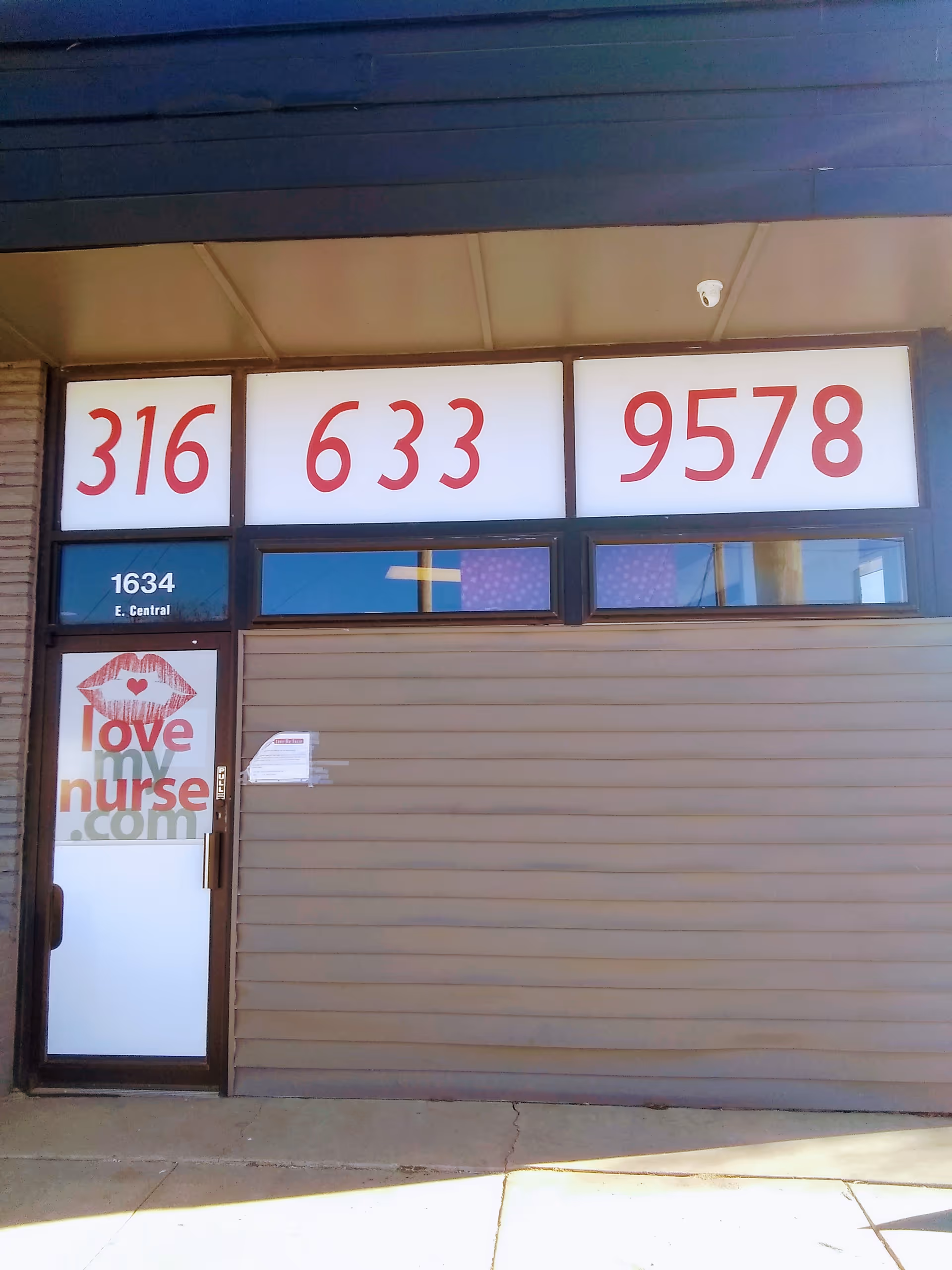 Front of a building with large numbers and a 'Love My Nurse' sign on the door.