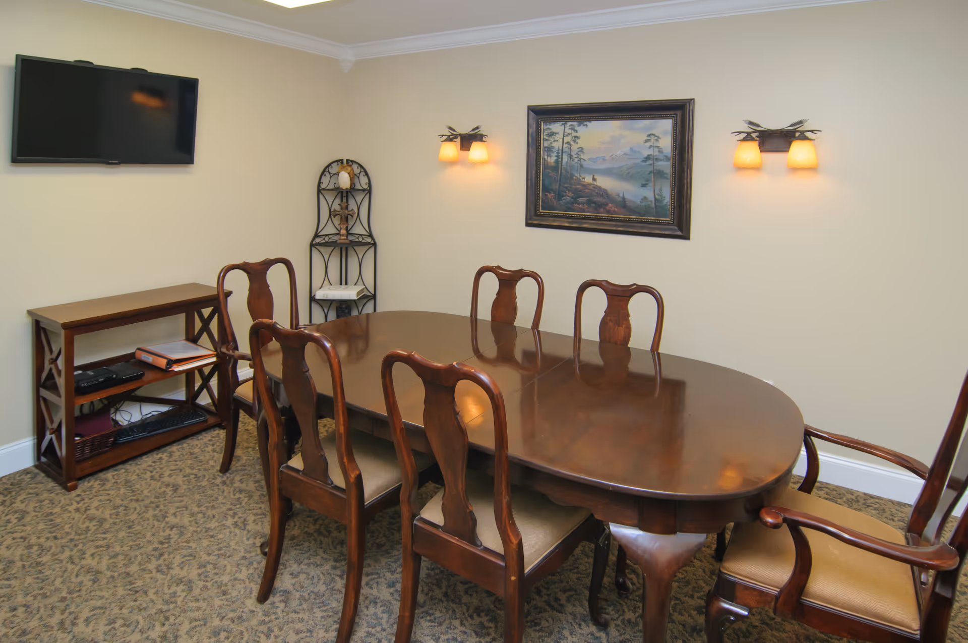 Wooden dining table with chairs in a well-lit beige dining room.