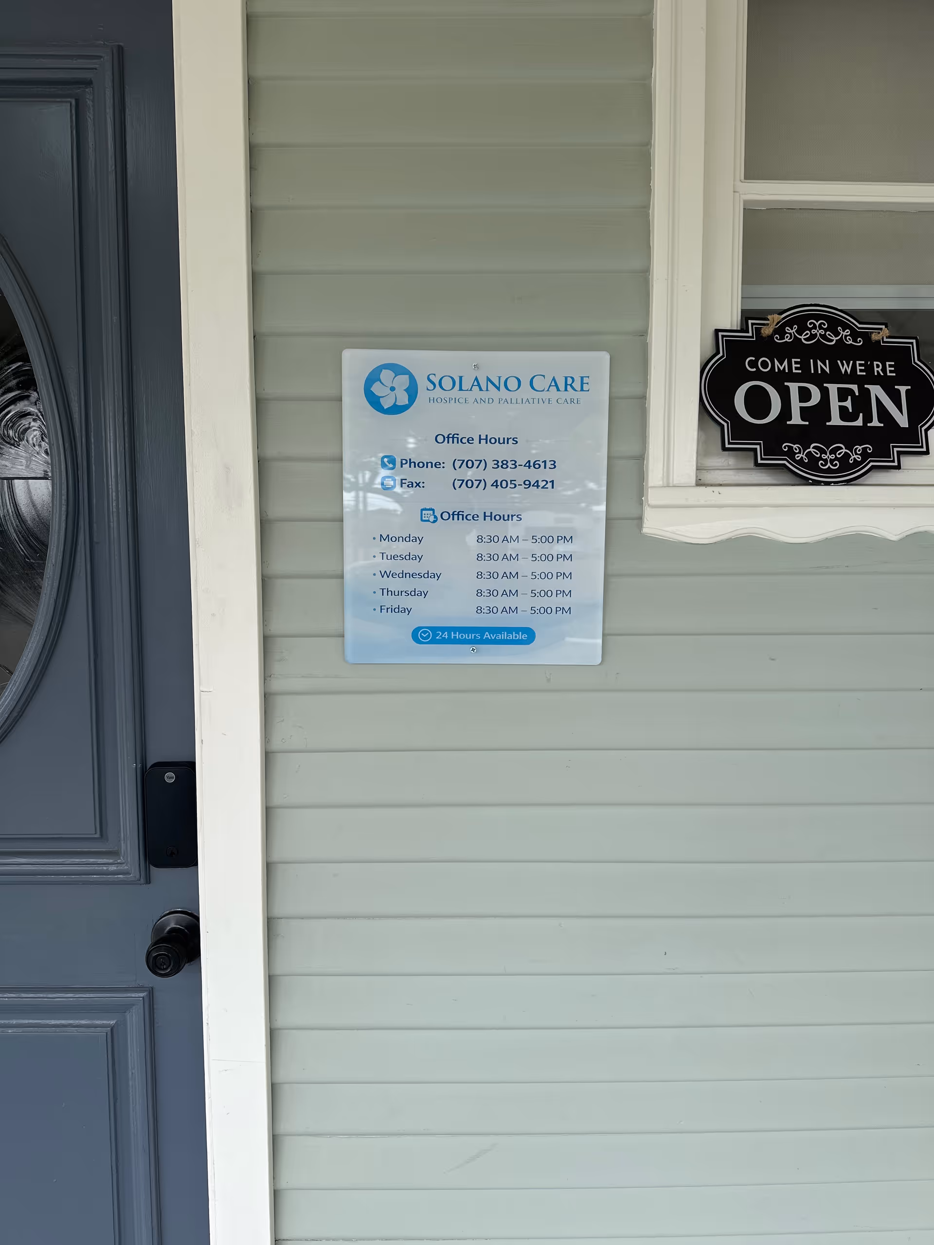 Front exterior of Solano Care building with an OPEN sign and hours notice.