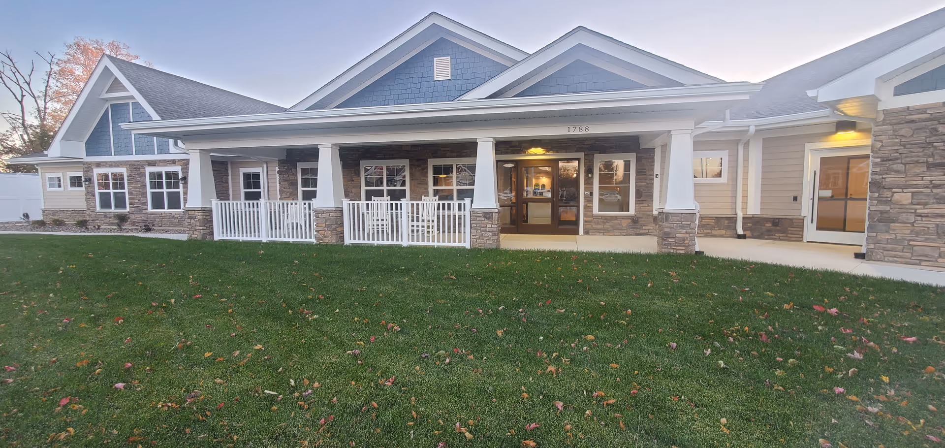 Single story senior living facility exterior with a covered entrance and well maintained green lawn.