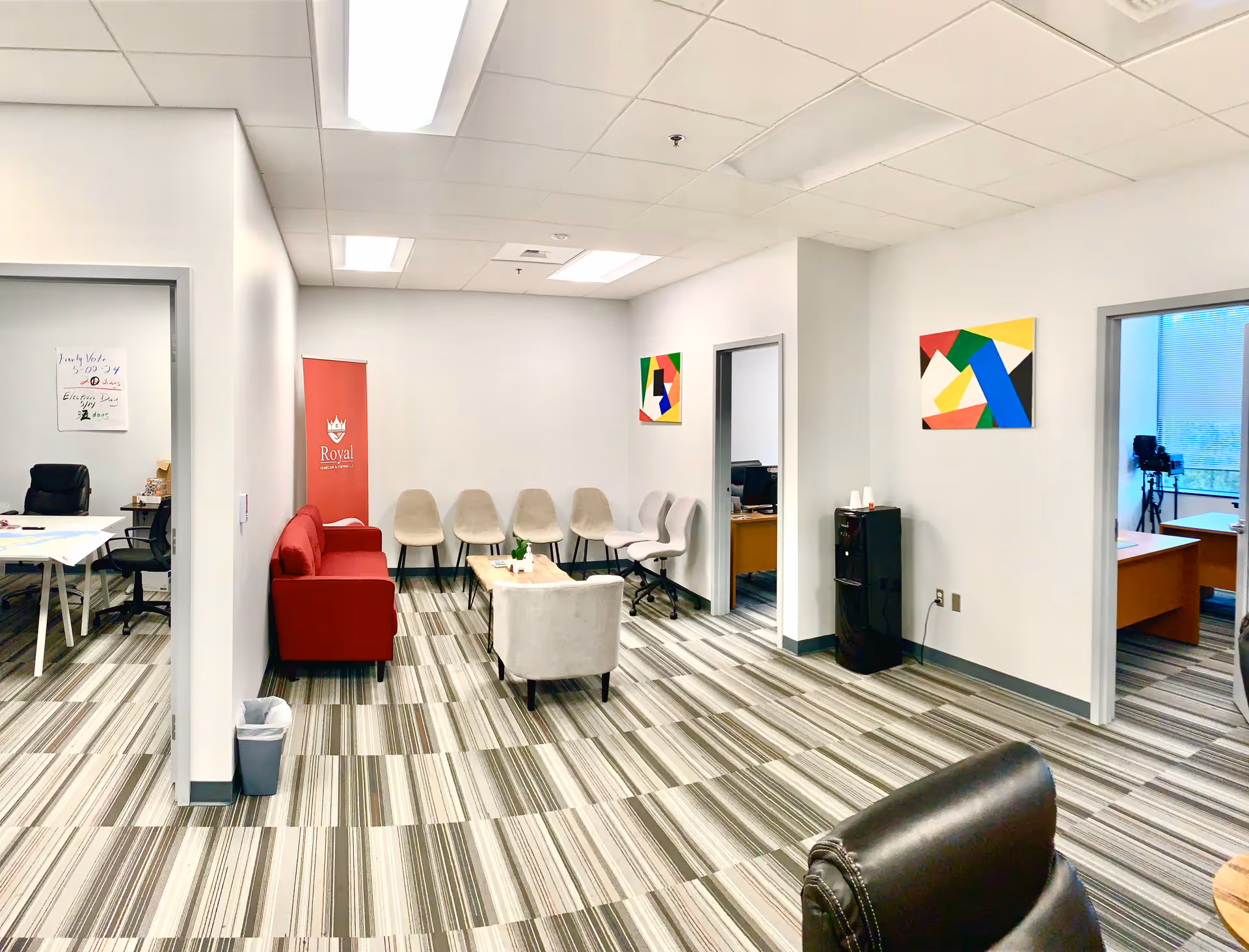 Bright modern lounge in a Royal Home Care facility with chairs and artwork.