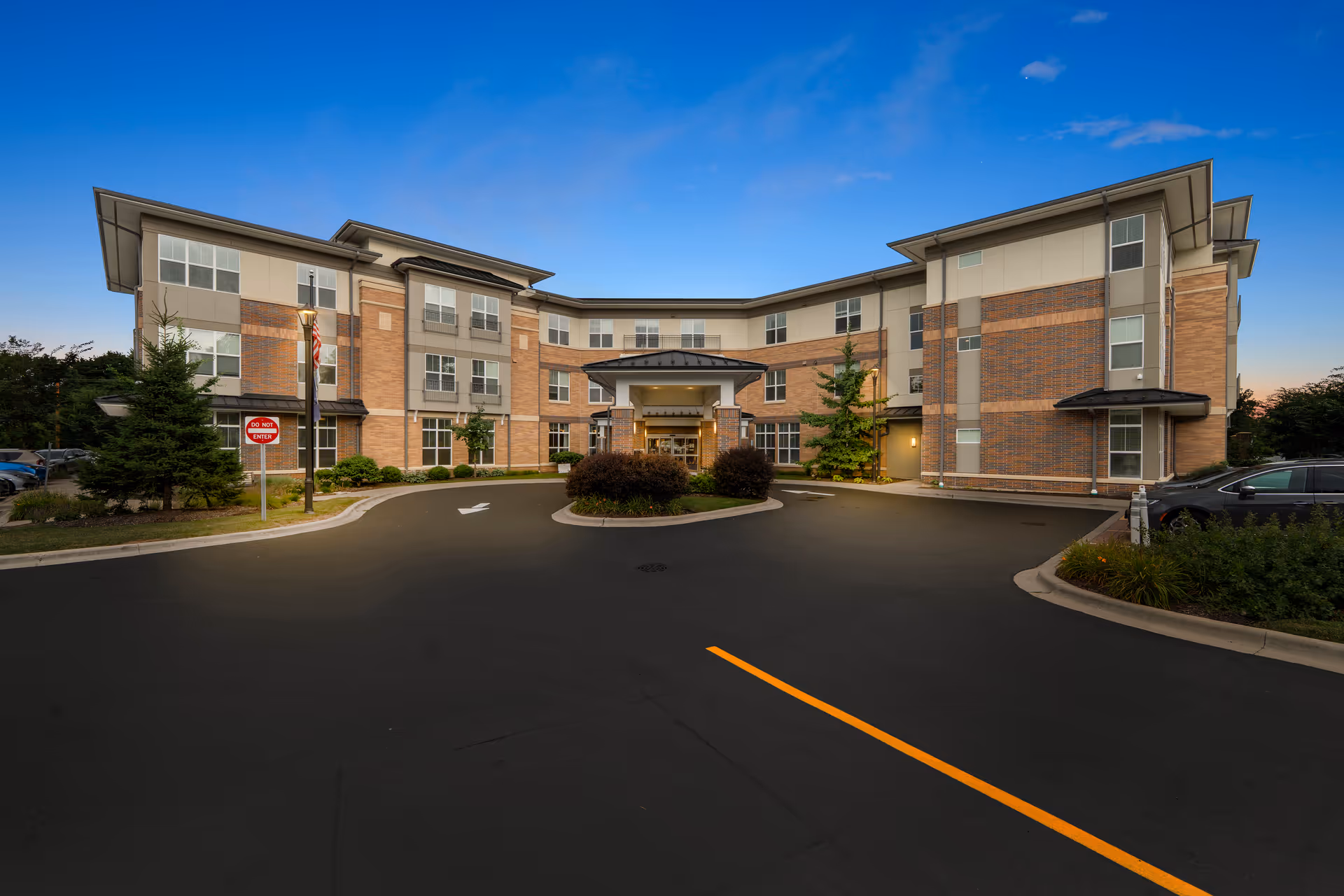 Exterior view of Arbor Terrace Highland Park building with circular driveway and entrance.