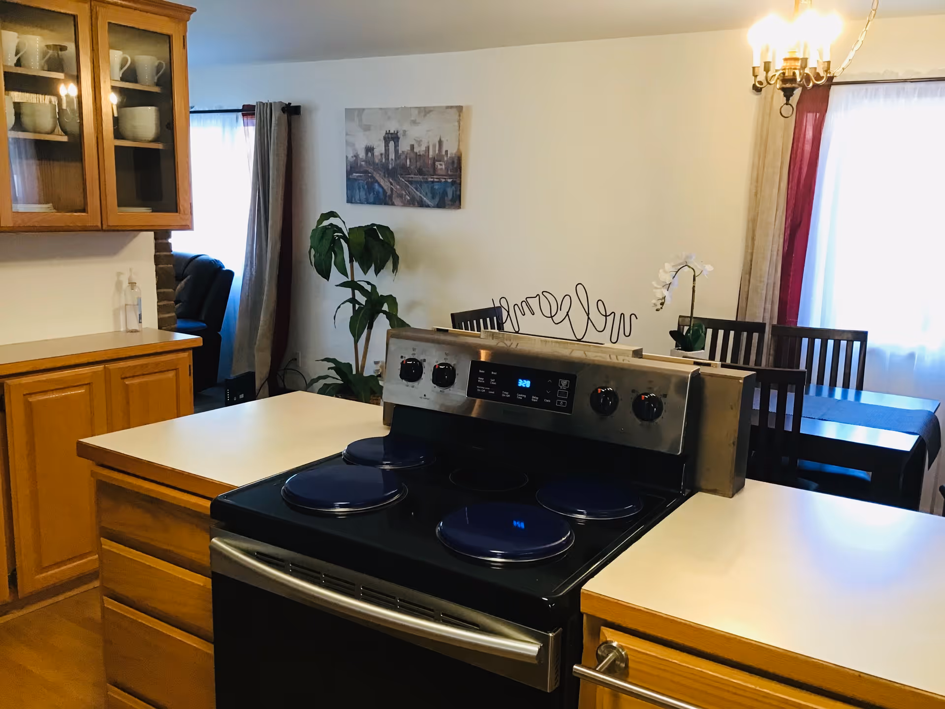 Modern kitchen with stove, wooden cabinets, countertops, and a dining table in a cozy setting.