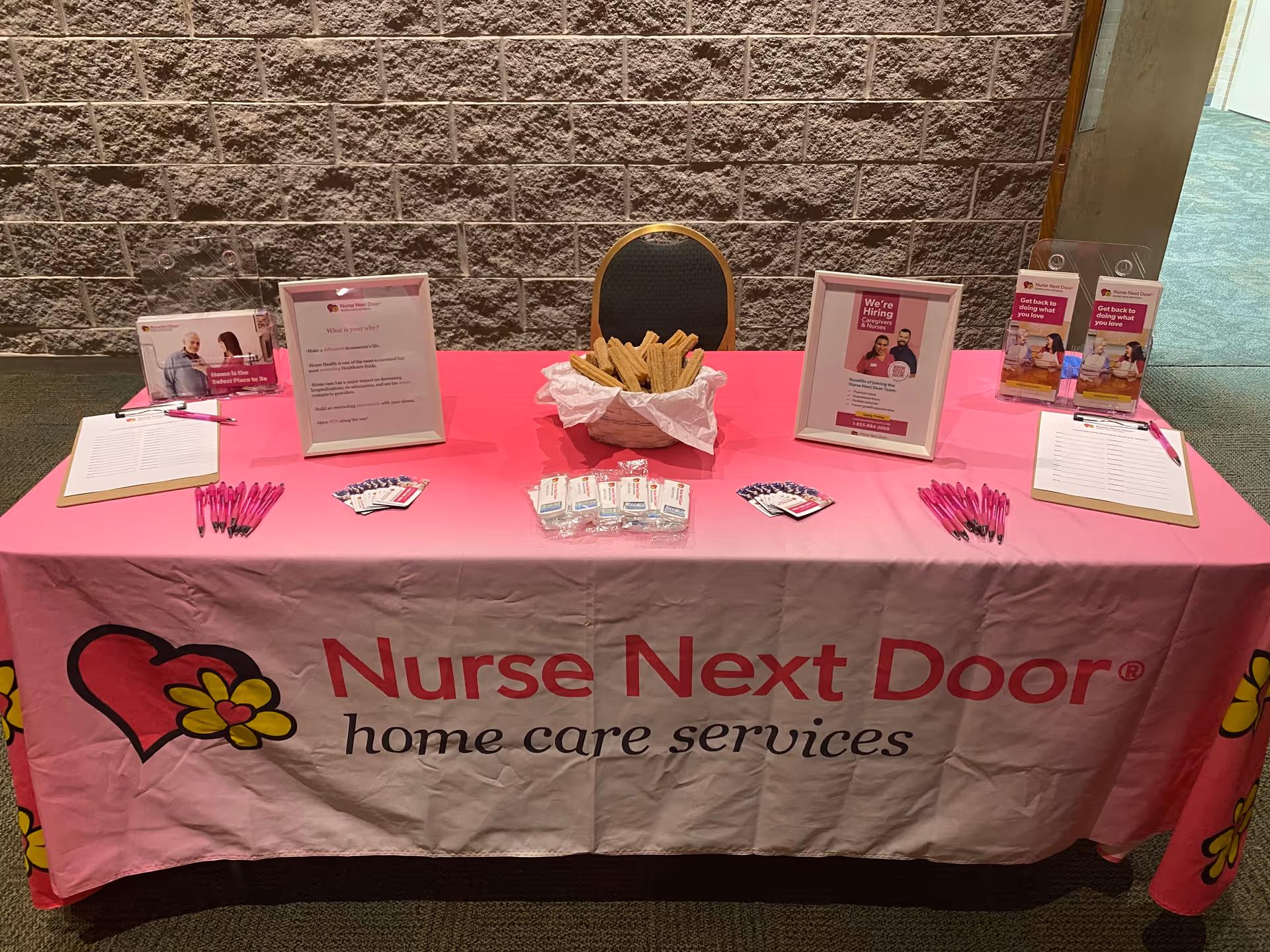 Promotional table for Nurse Next Door home care services in an interior hallway.