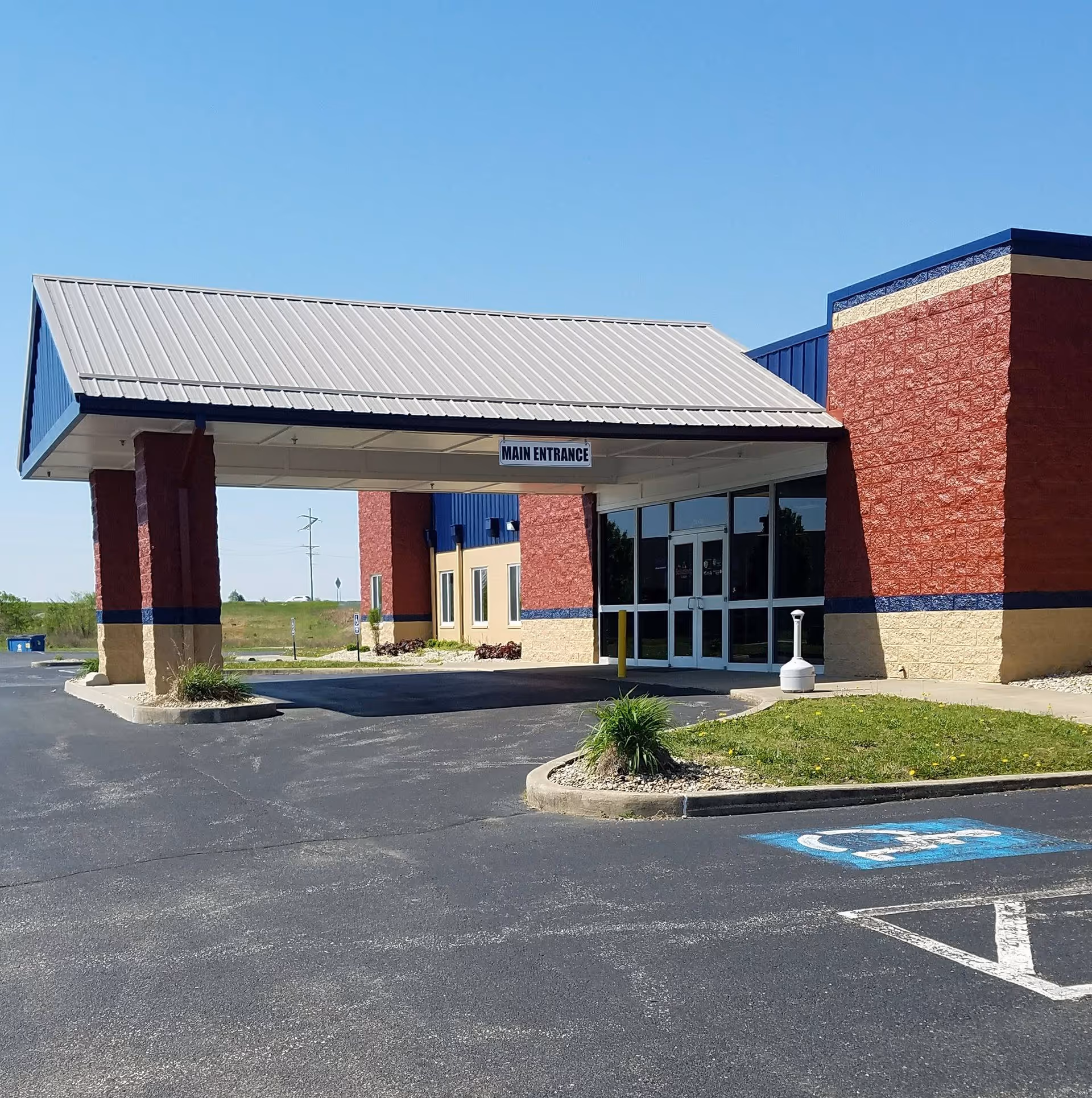 View of the senior living facility entrance with a covered driveway and parking.