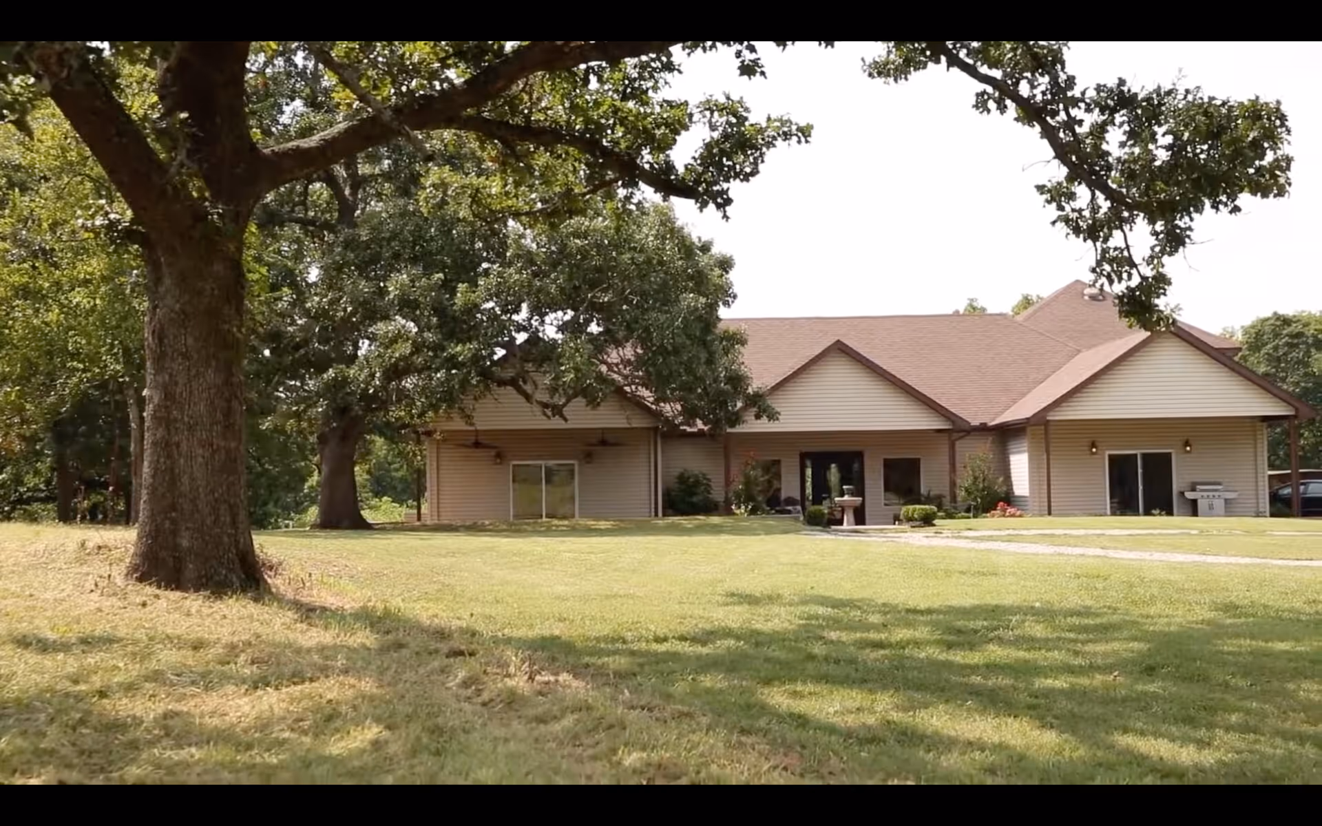 Exterior view of a single-story senior living facility with a lawn and trees.