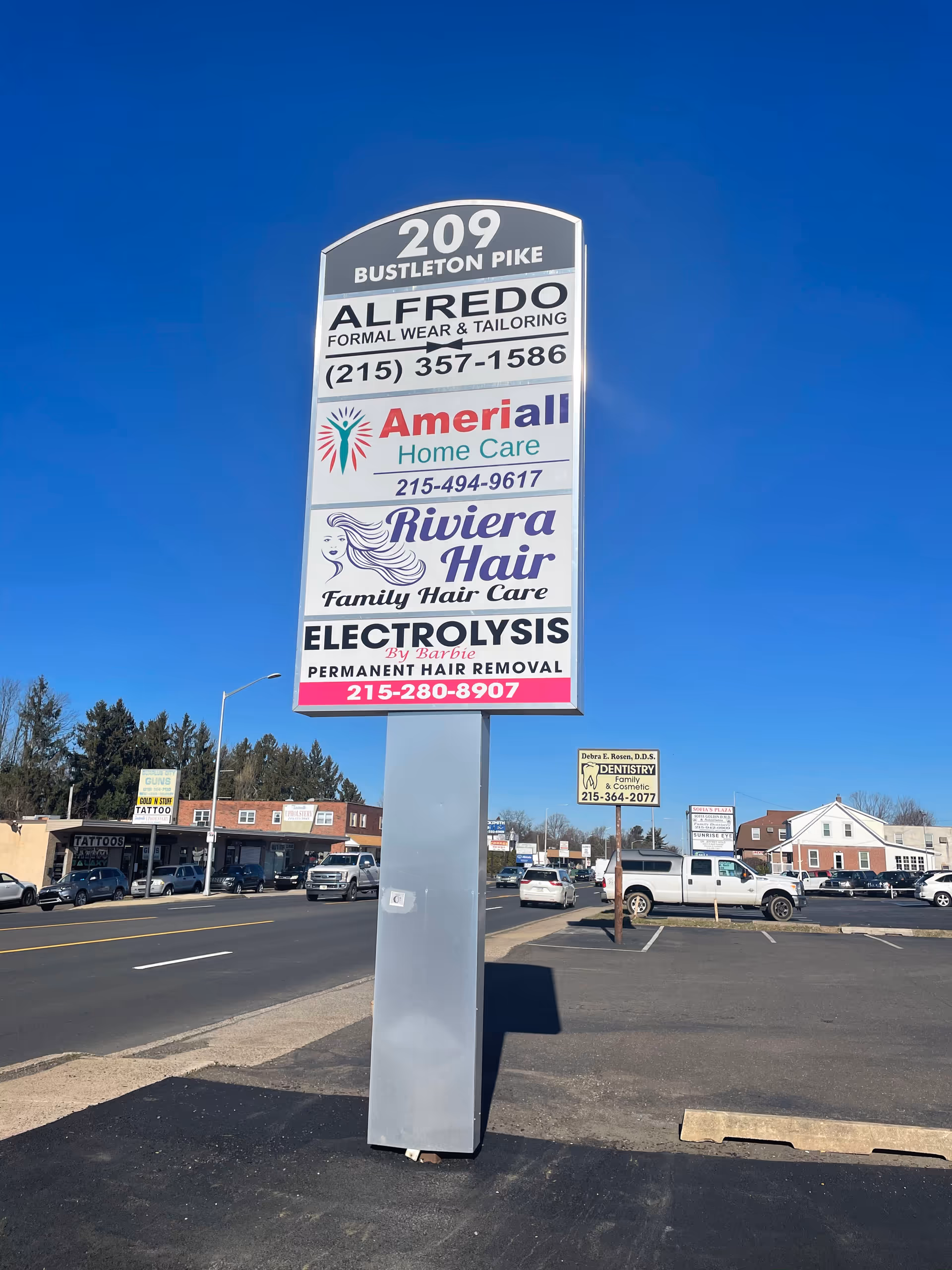 Tall outdoor sign in a parking lot displaying Ameriall Home Care among other businesses.