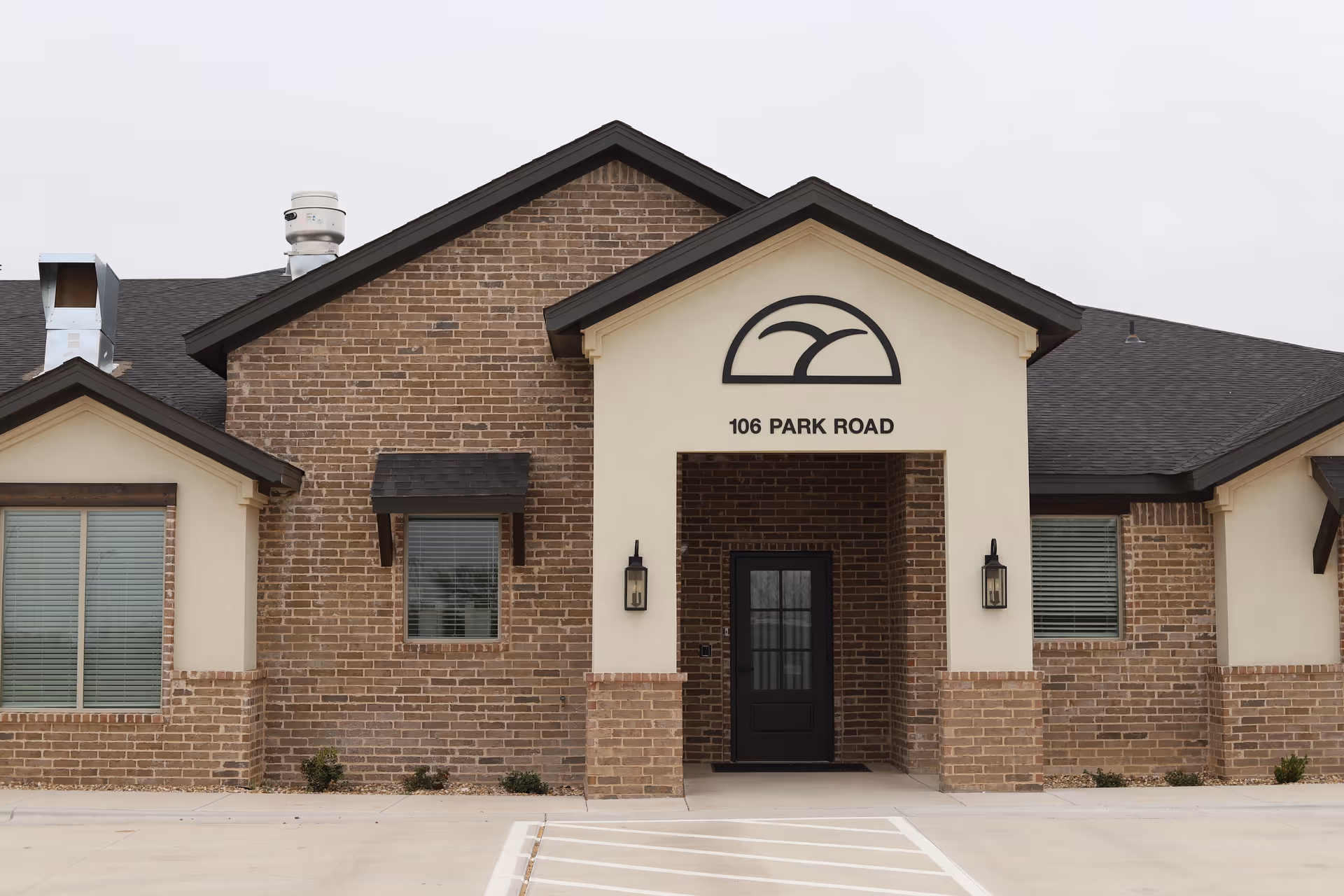A brick building entrance features an arched sign and the address 106 Park Road.