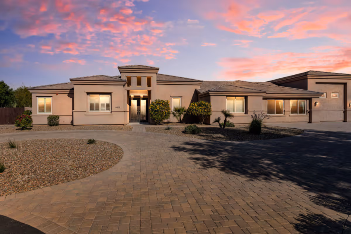 A single-story senior living facility exterior with a circular driveway and desert landscaping.
