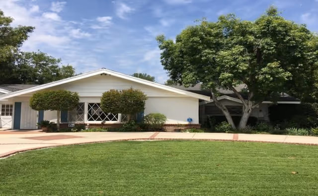 Front view of Walnut Acres Residential Care with manicured lawn and trees.