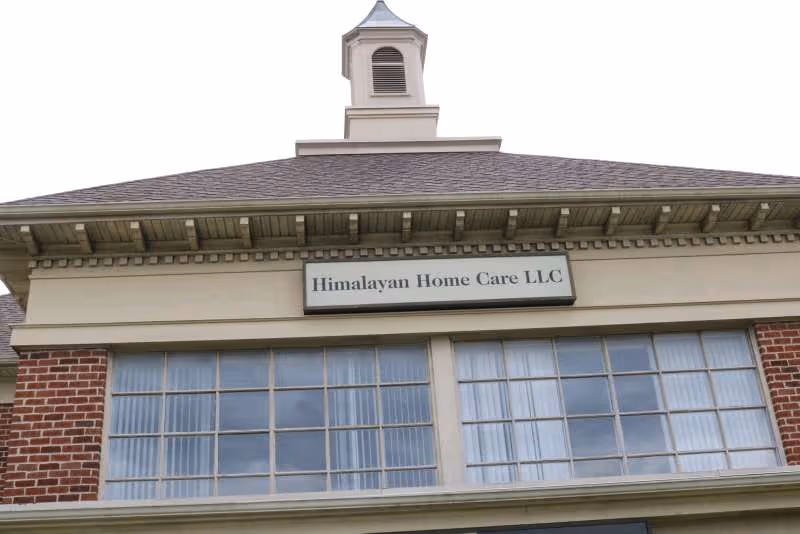Front exterior of Himalayan Home Care LLC building with sign and large windows.