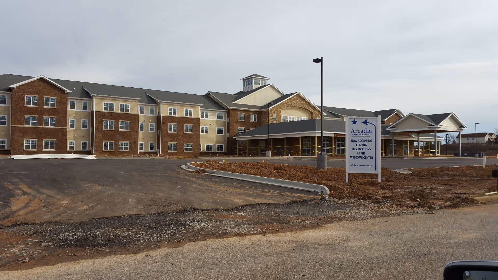 Exterior view of Arcadia Senior Living Clarksville building with driveway and sign.