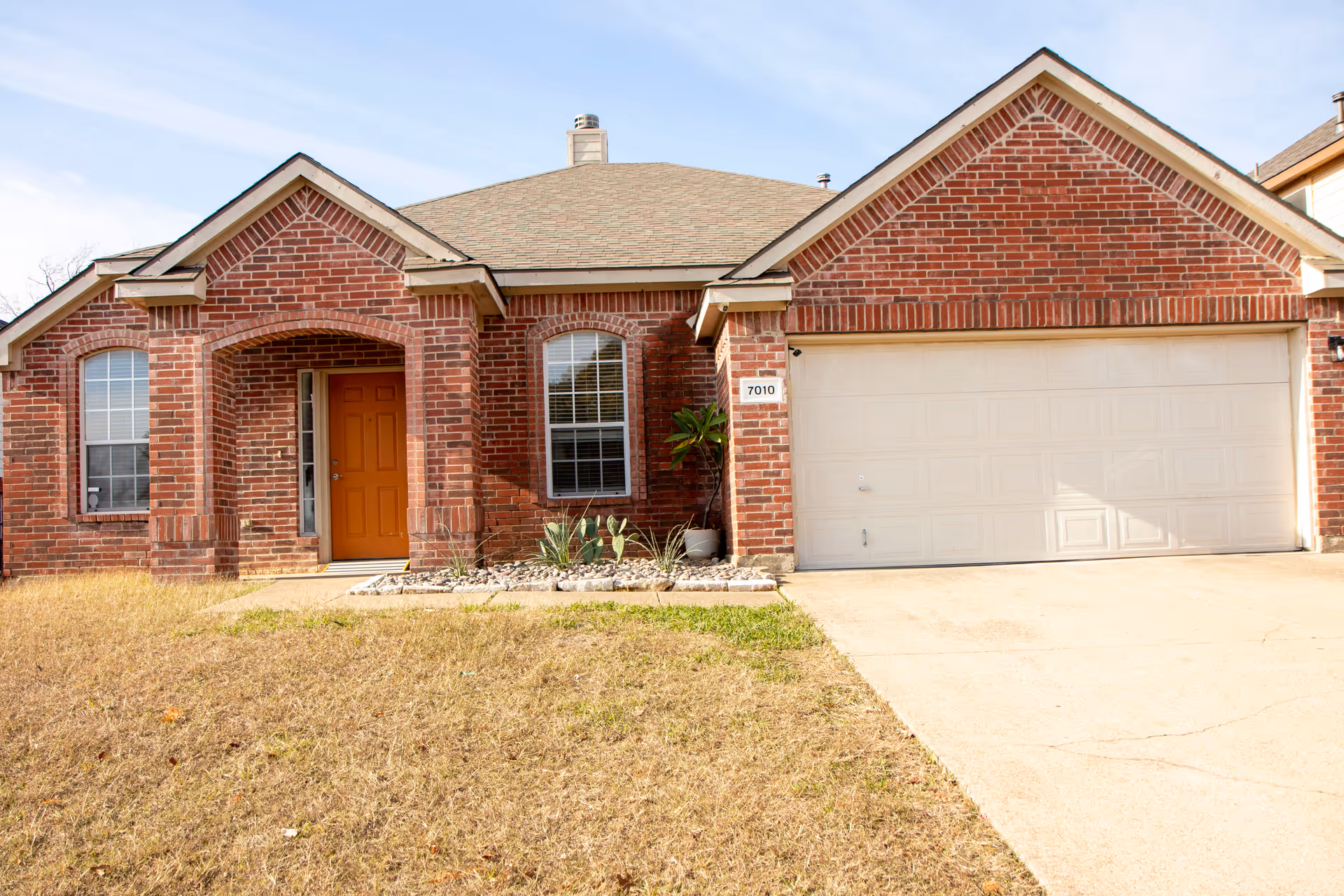 Front view of a brick, single-story house with a two-car garage.