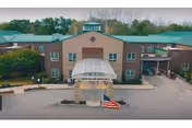 Exterior of a brick senior living facility with a glass entrance canopy.