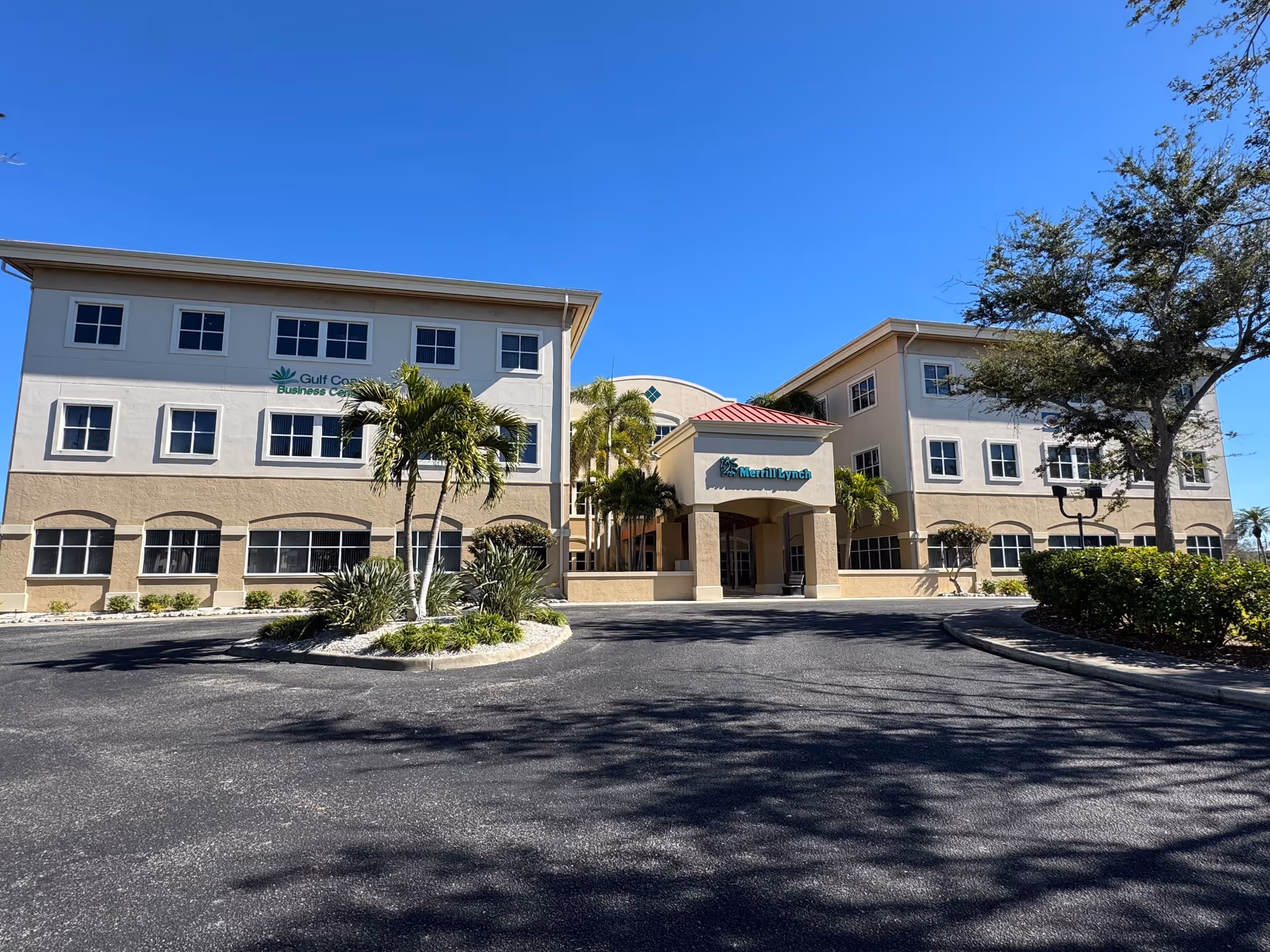 Exterior view of a two-story senior care facility with palm trees and a driveway.