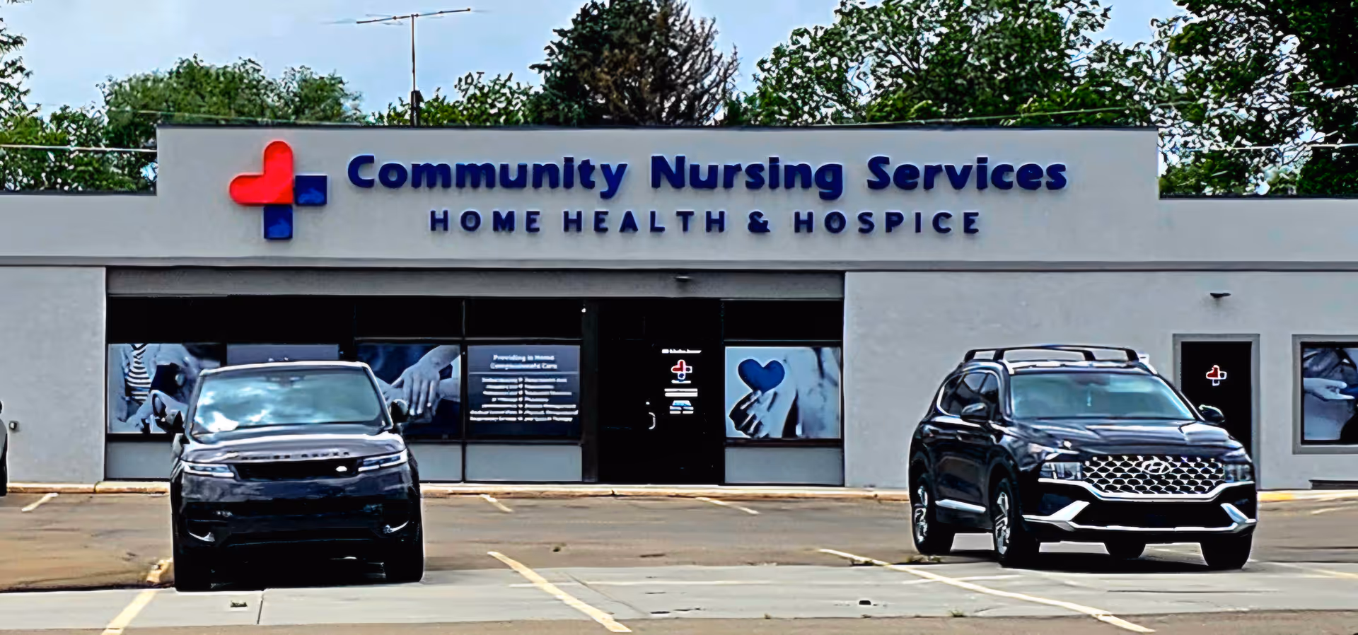Front exterior of Community Nursing Services with two parked SUVs in the lot.