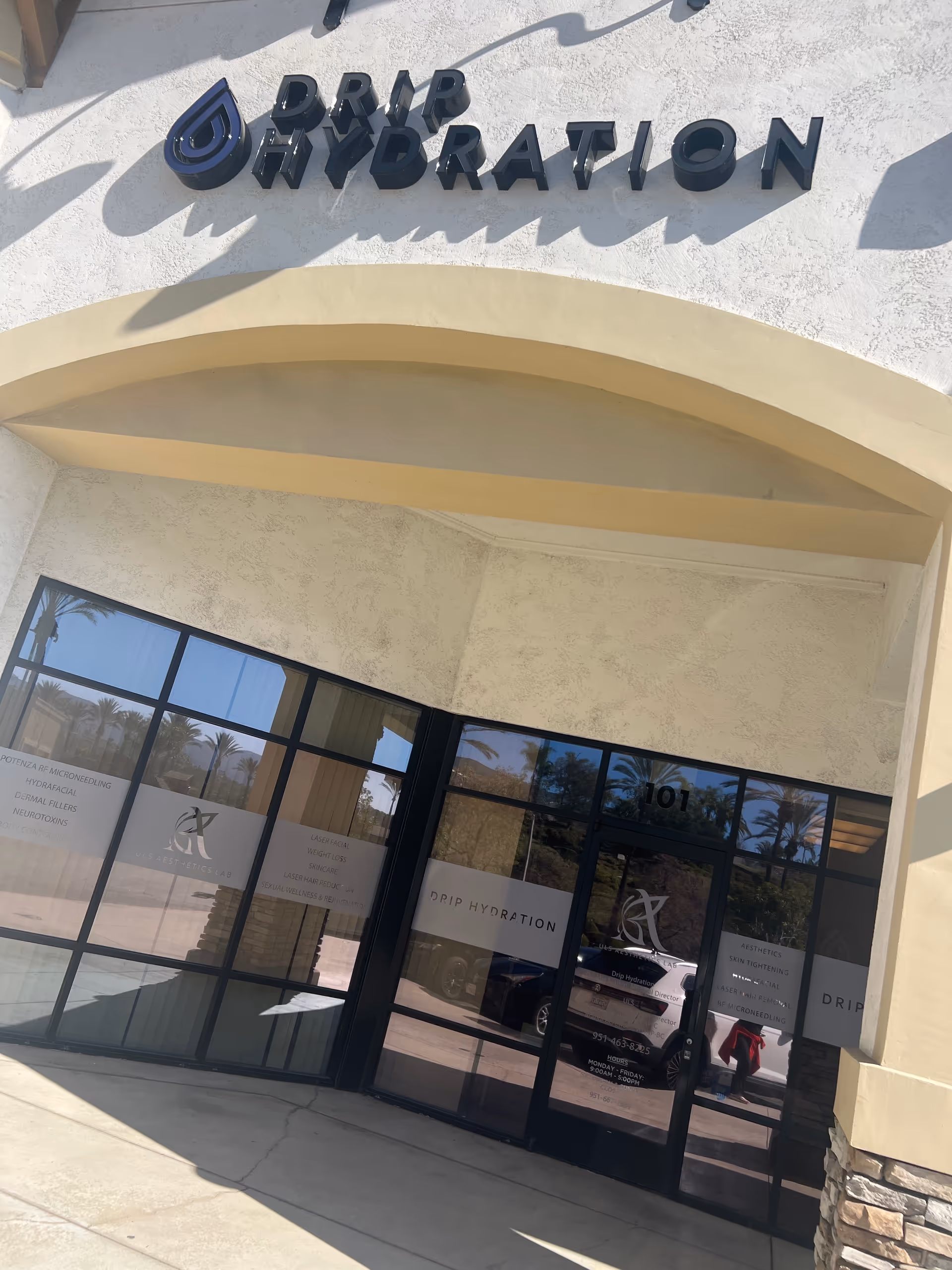 Exterior view of Drip Hydration facility entrance with glass doors.