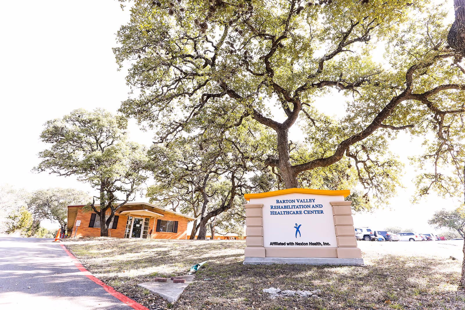 Exterior view of Monte Siesta Nursing & Rehabilitation with a large sign and tall trees.