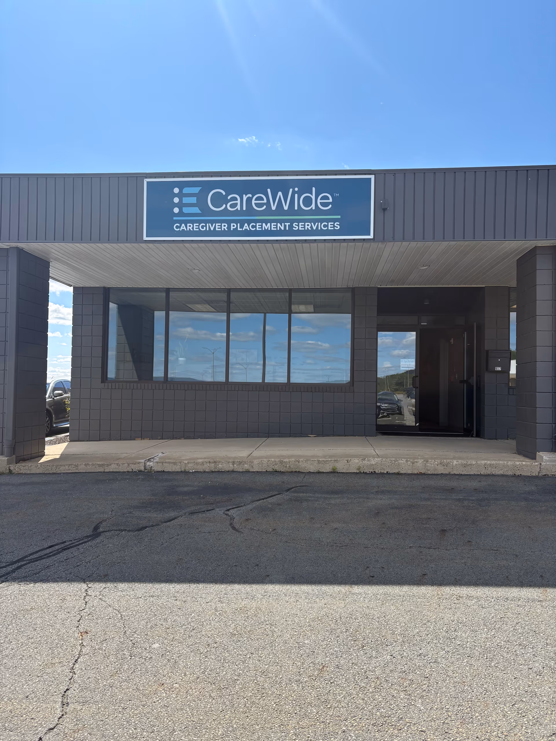 Front view of a CareWide facility entrance with sign and glass windows