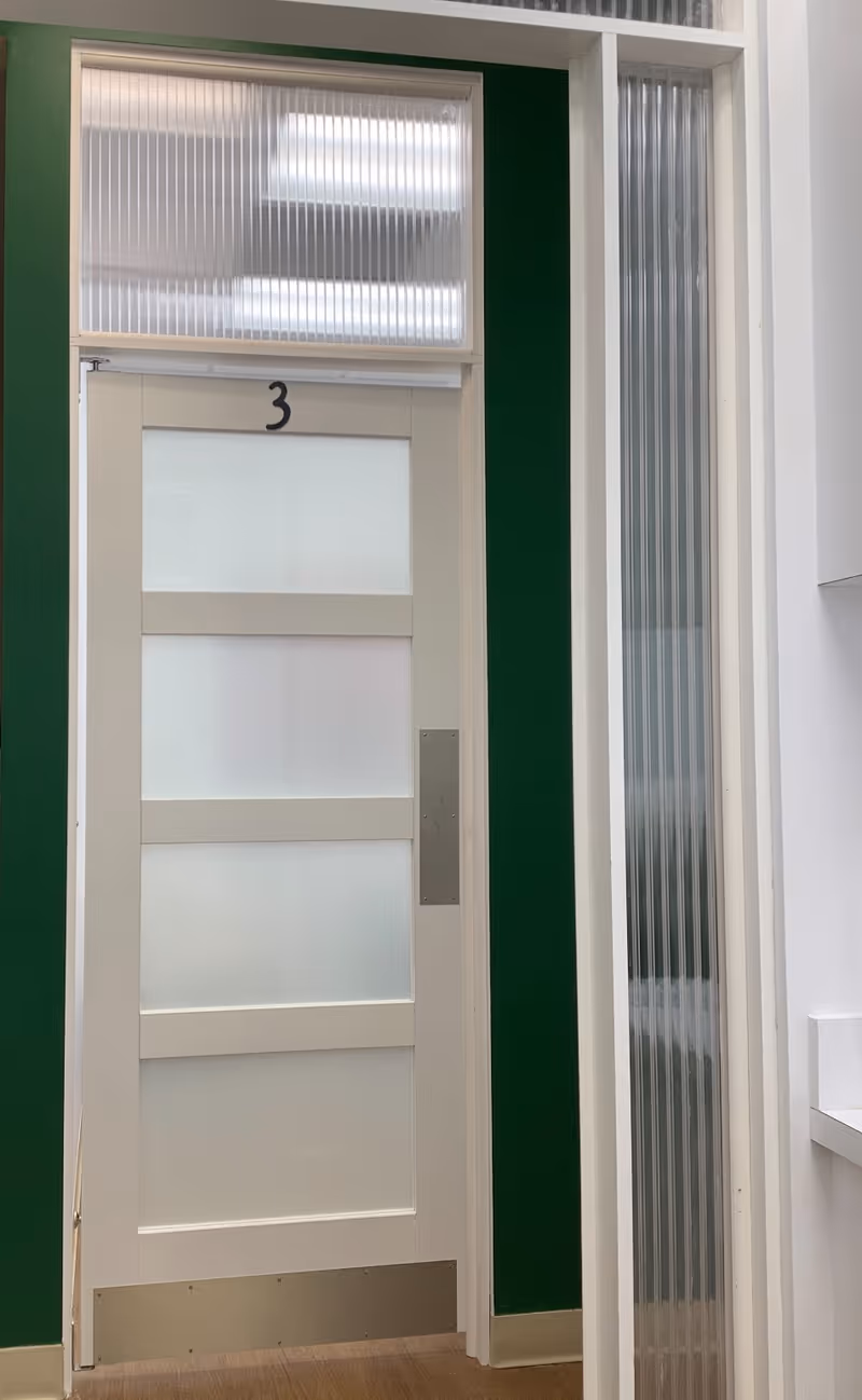 White door with frosted glass panels labeled 3, set in a green-walled interior.