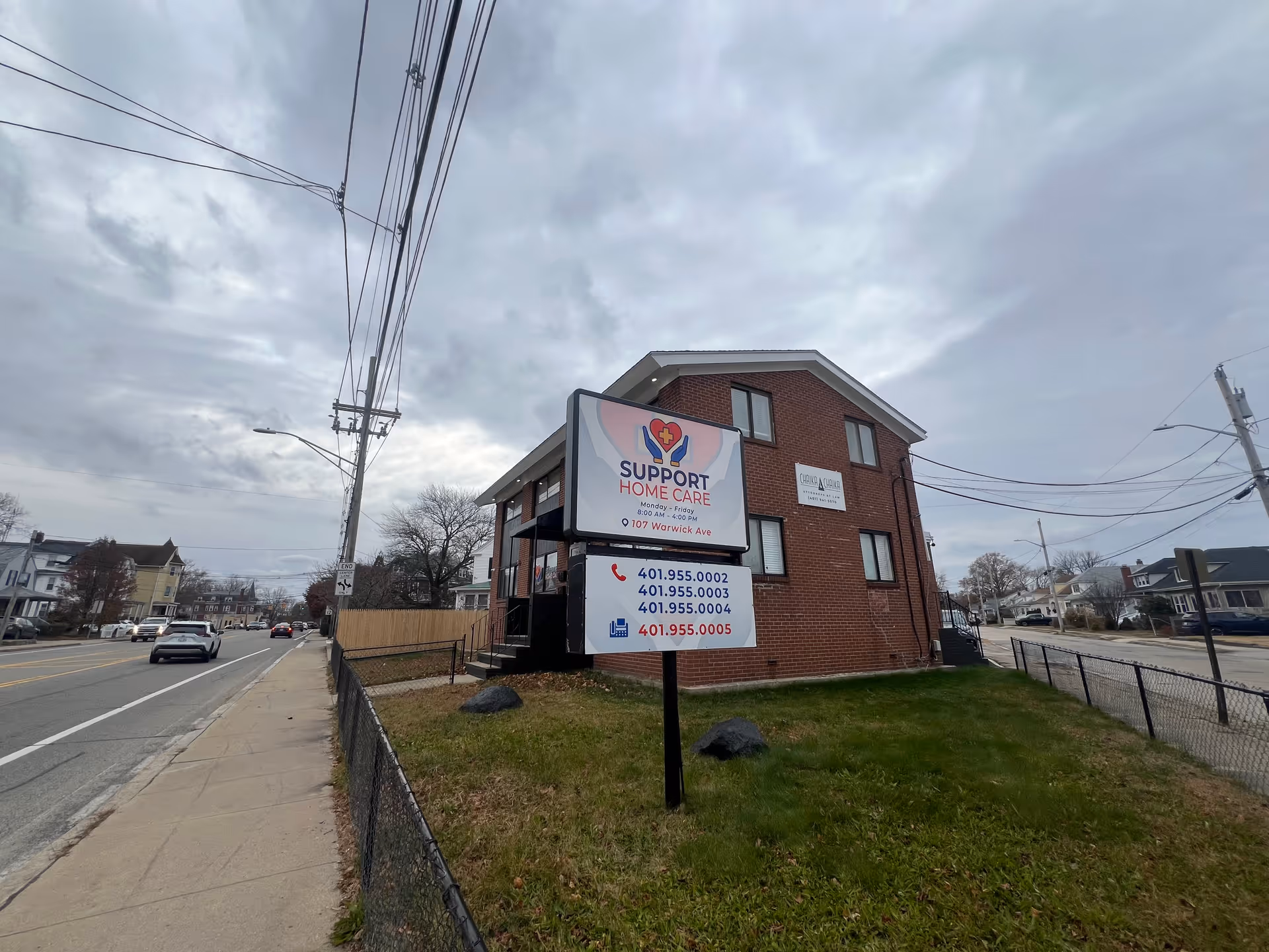 Brick building on a street with a large Support Home Care sign