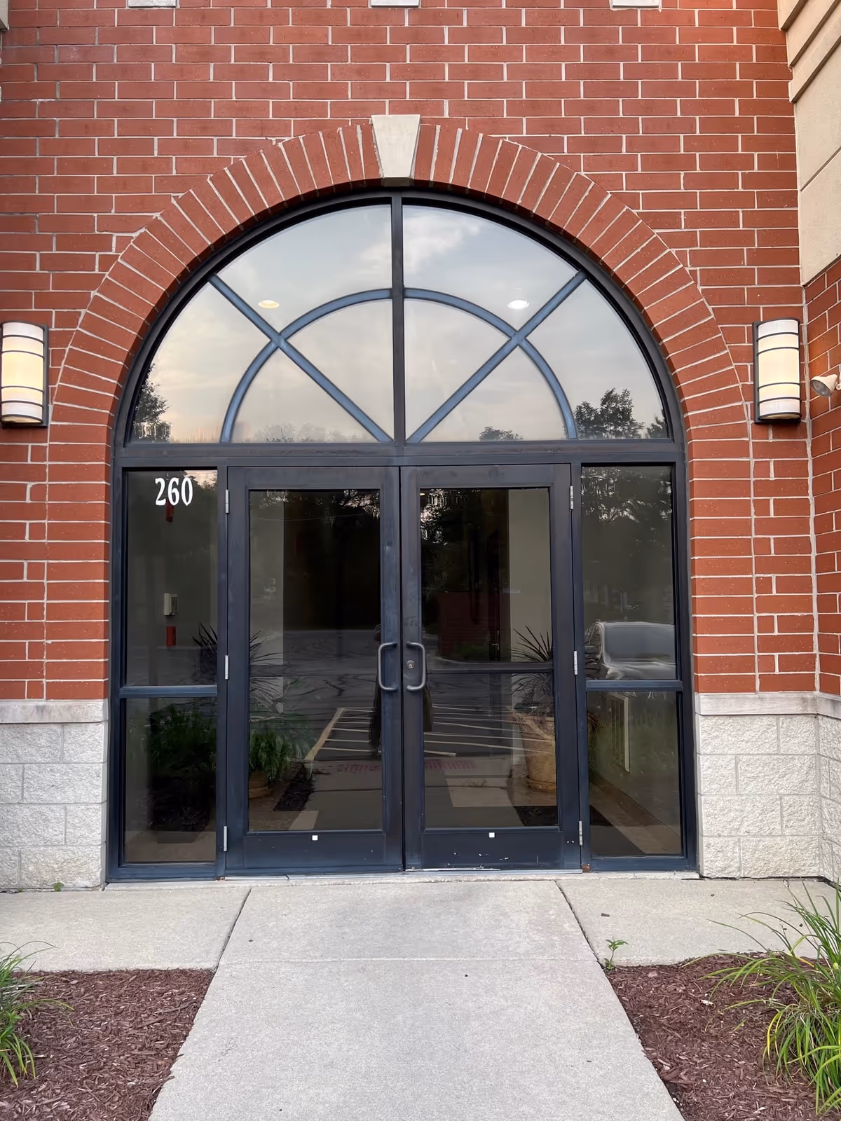 Brick building entrance with arched glass doorway and double doors, labeled 260.