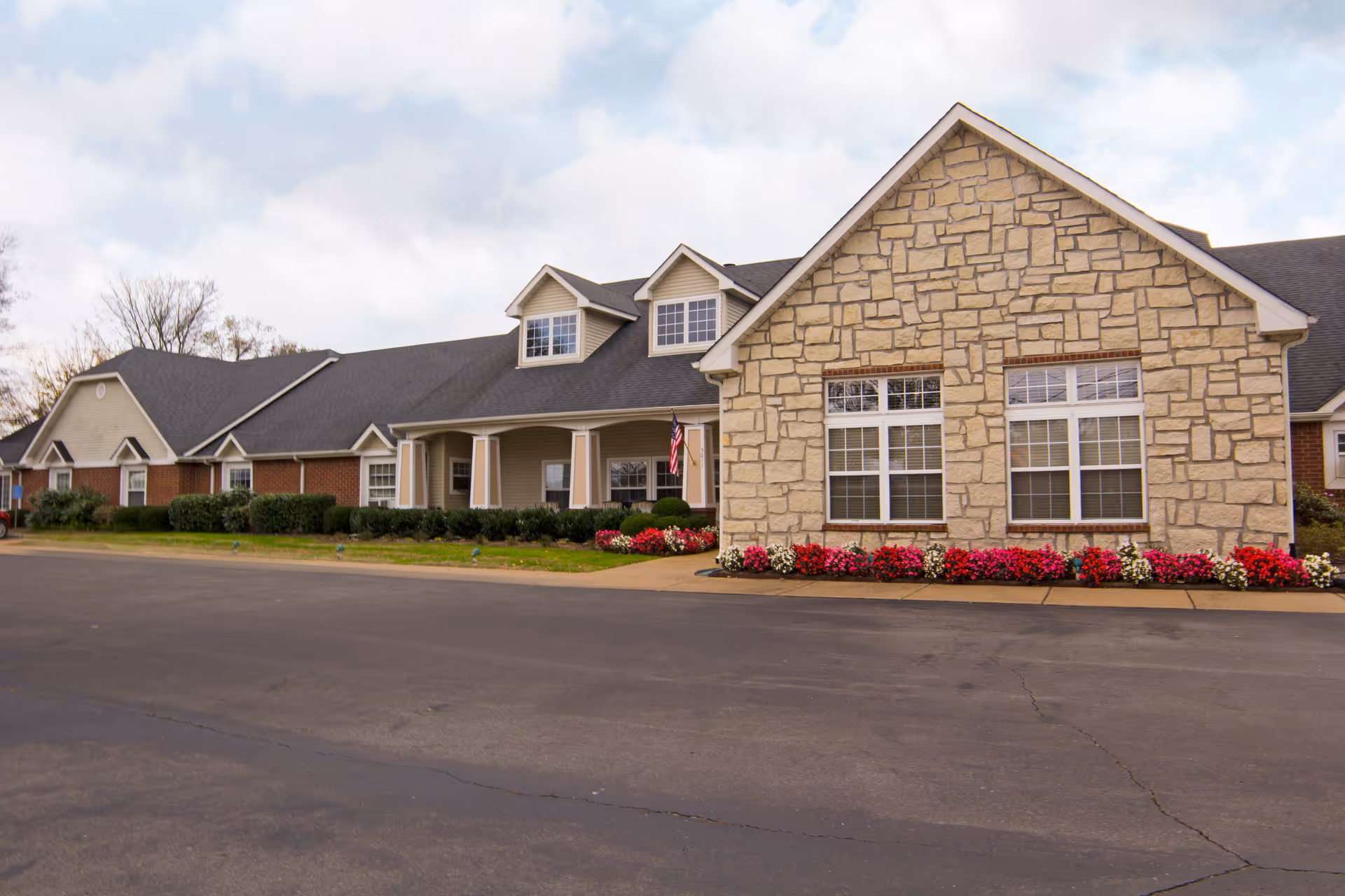 Exterior view of a Brookdale Columbia senior living facility with stone front and flowers.