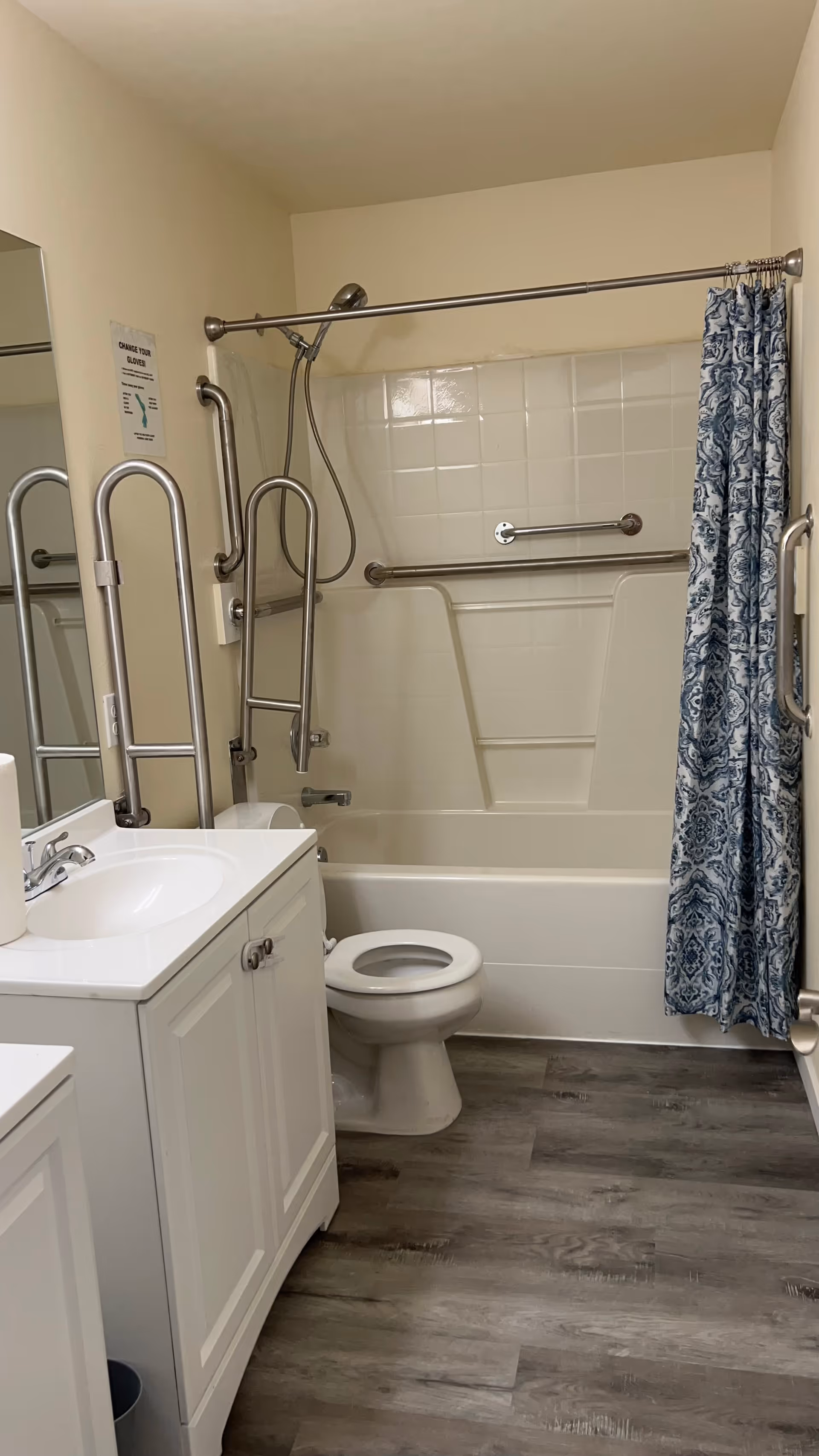 Accessible bathroom with shower, tub, grab bars, and sink in a senior living facility.